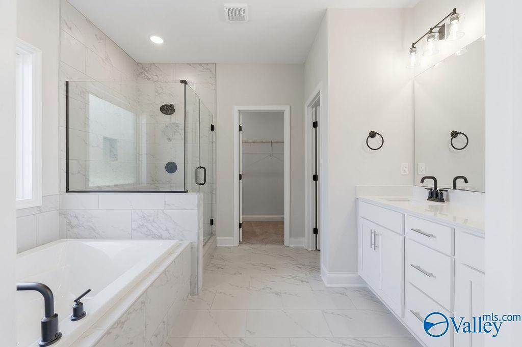 Modern master bathroom featuring glass shower, freestanding tub, and double vanity in Davidson Homes The Montgomery B, Hartselle, Alabama