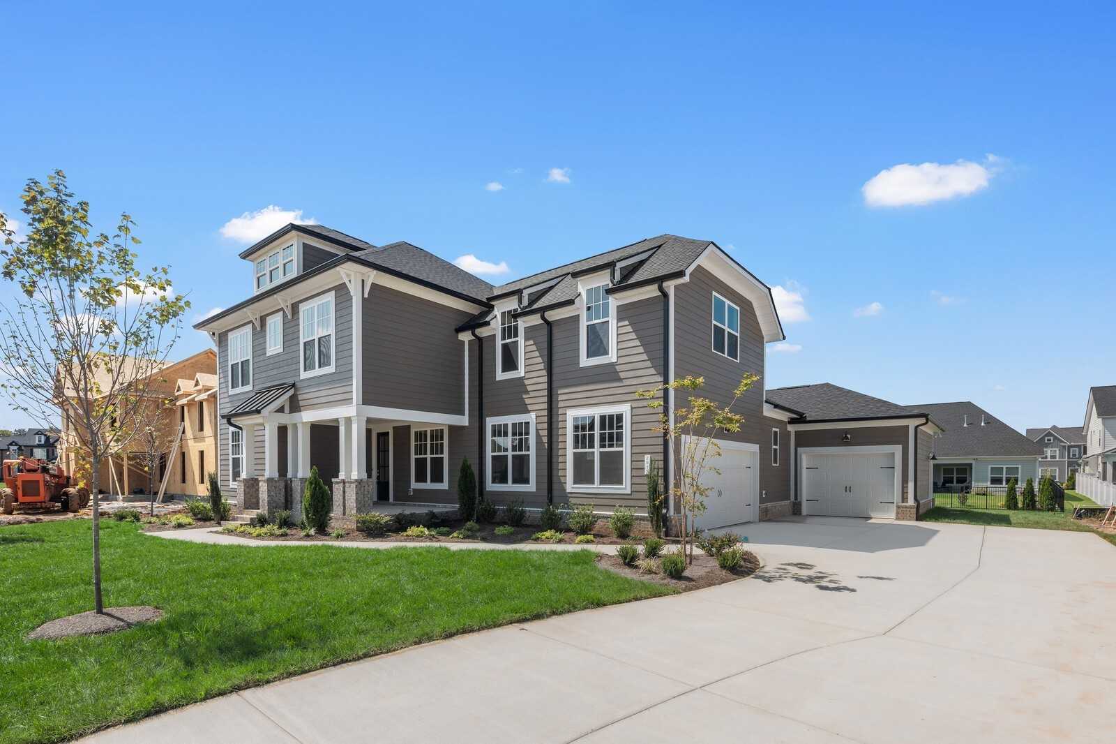 Modern two-story gray home with three-car garage, front porch, and landscaped yard in Shelton Square, Murfreesboro, Tennessee