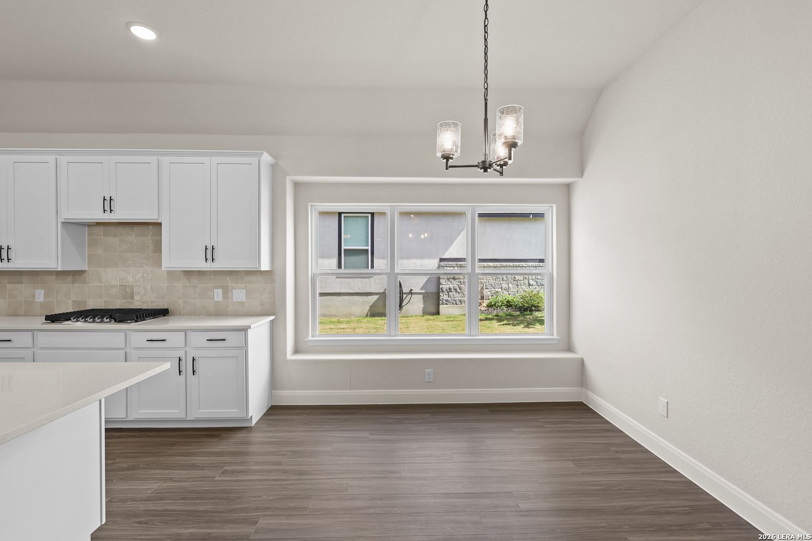 Bright breakfast nook with large window and chandelier in The Summerlin B floor plan by Davidson Homes, Castroville, Texas.