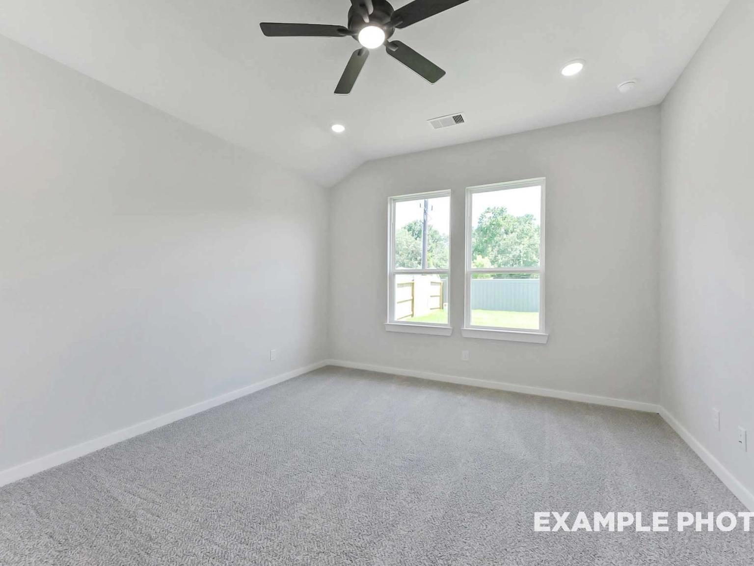 Bright bedroom with vaulted ceiling and carpeted floor in The Sequoia C floor plan at Sundance Cove, Crosby, Texas.