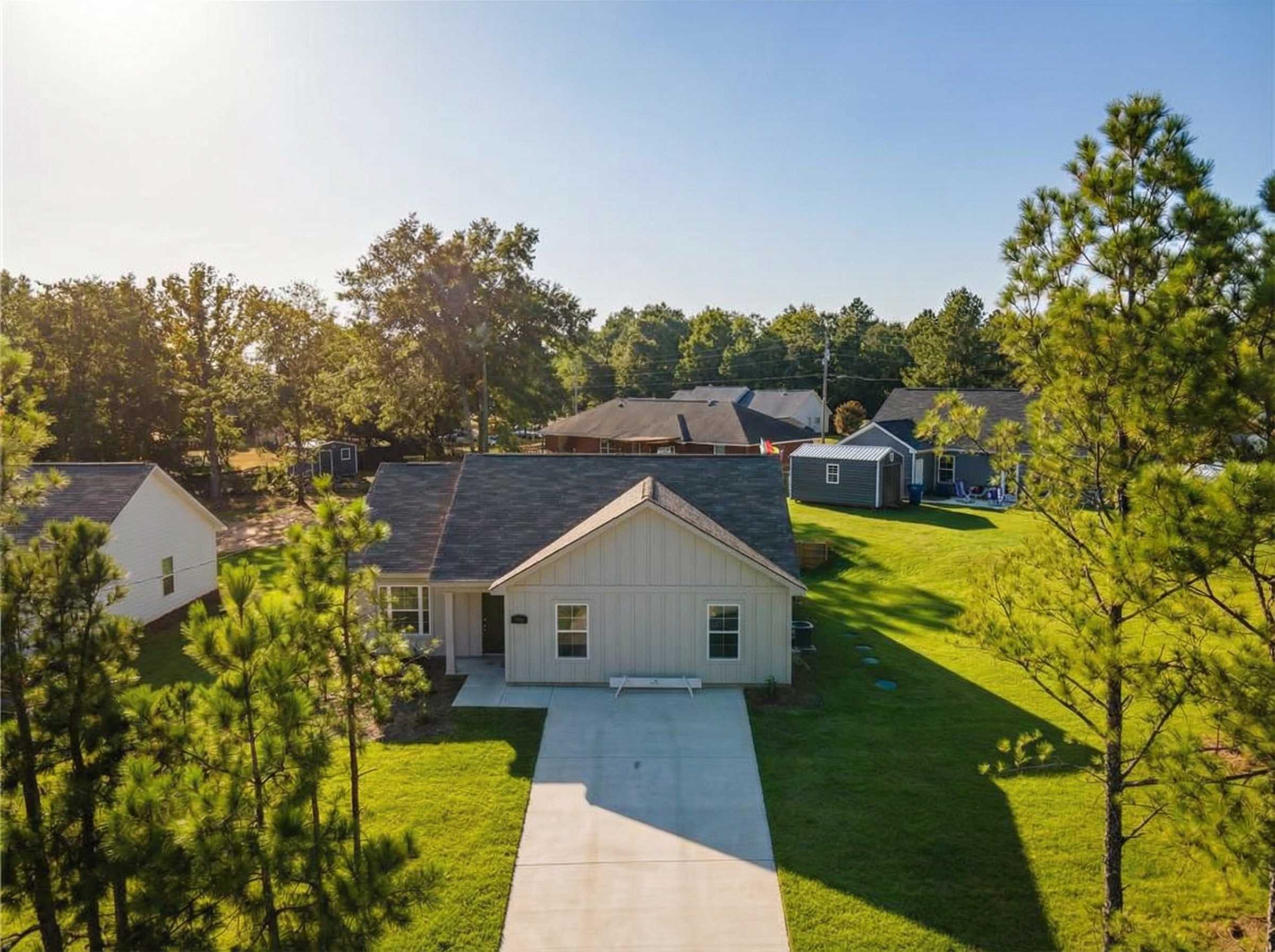 Aerial view of The Washington 3-bedroom single-story home by Evermore Homes in Heatherbrook, Phenix City, Alabama, with driveway and pine-shaded yard