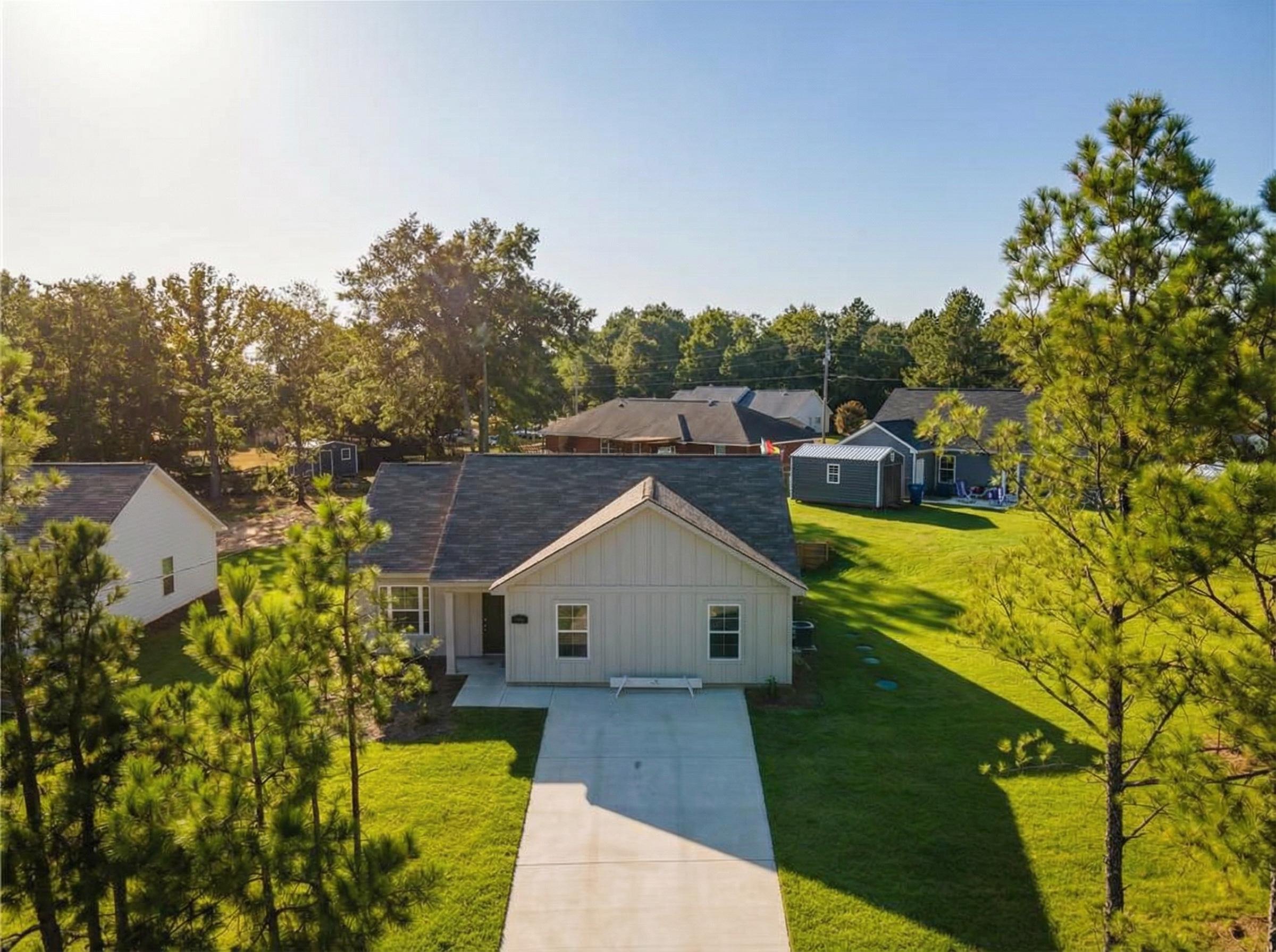 Aerial view of The Washington 3-bedroom single-story home by Evermore Homes in Heatherbrook, Phenix City, Alabama, with driveway and pine-shaded yard