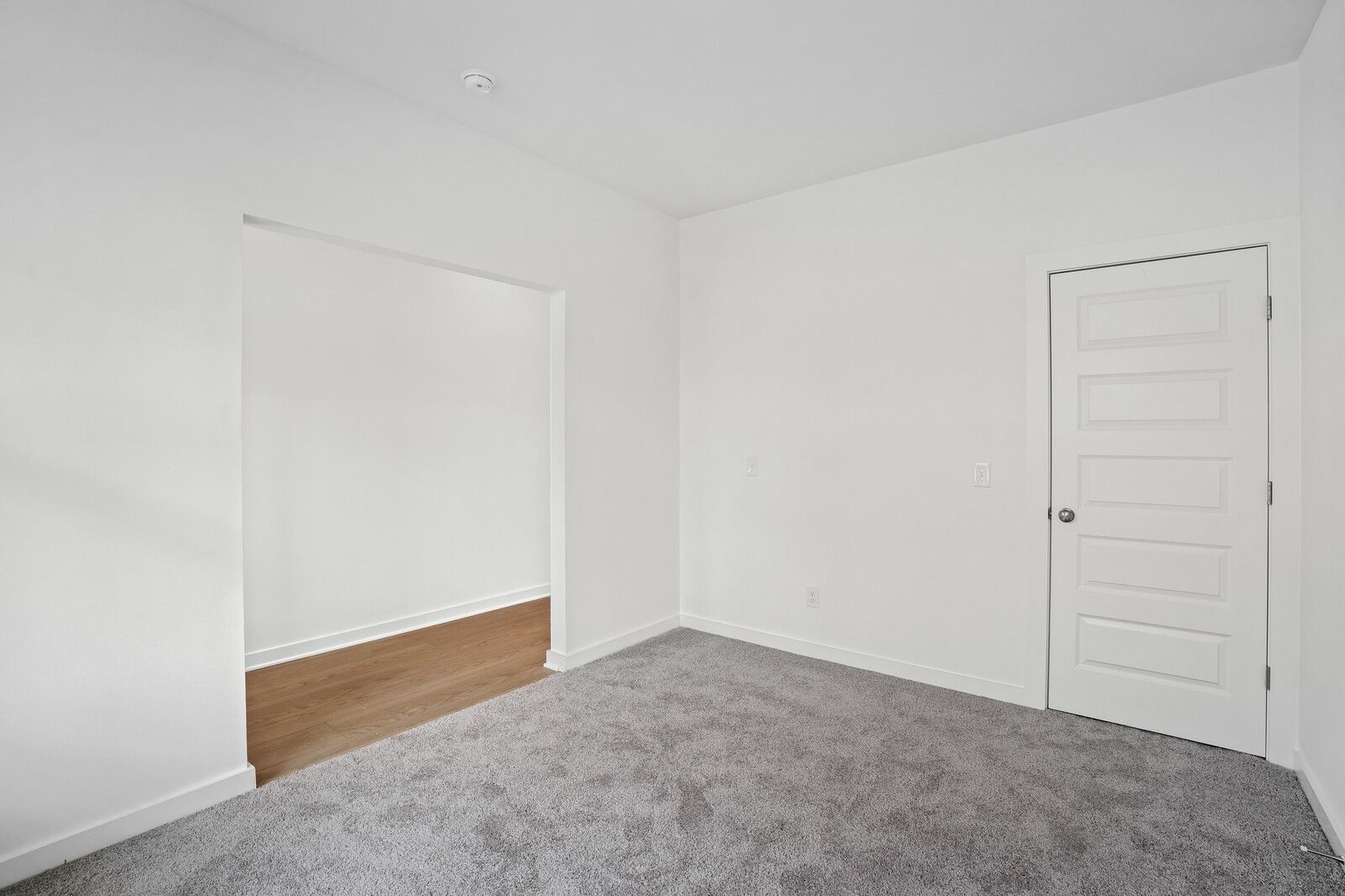Bright secondary bedroom with walk-in closet, gray carpet, and white walls in Davidson Homes The Logan C, White House, Tennessee