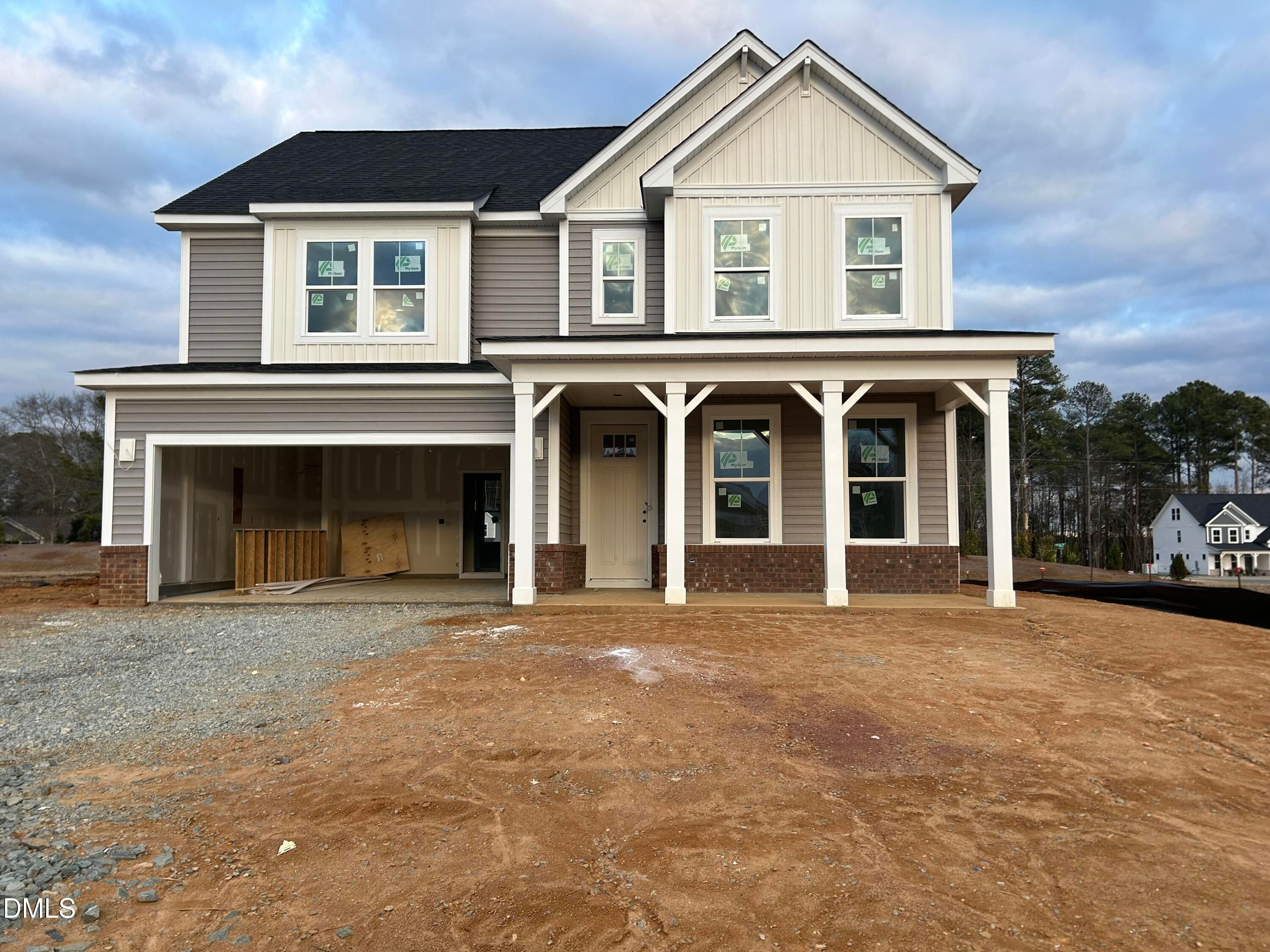 Modern two-story Chestnut B home with gray siding, front porch, and open two-car garage in Lillington, North Carolina
