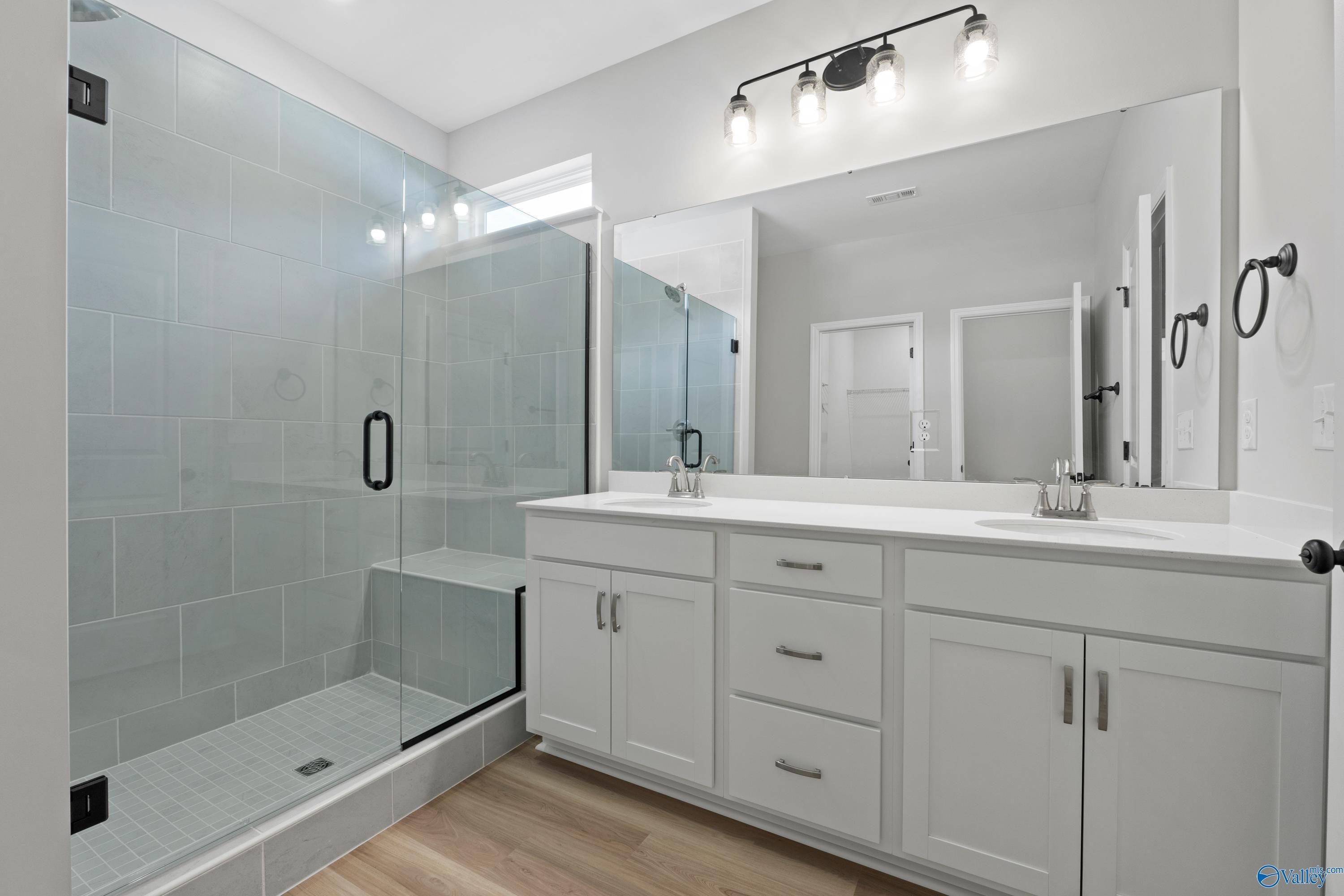 Modern master bathroom with frameless glass shower, subway tile, double white vanity in Davidson Homes The Phoenix, Fayetteville, TN