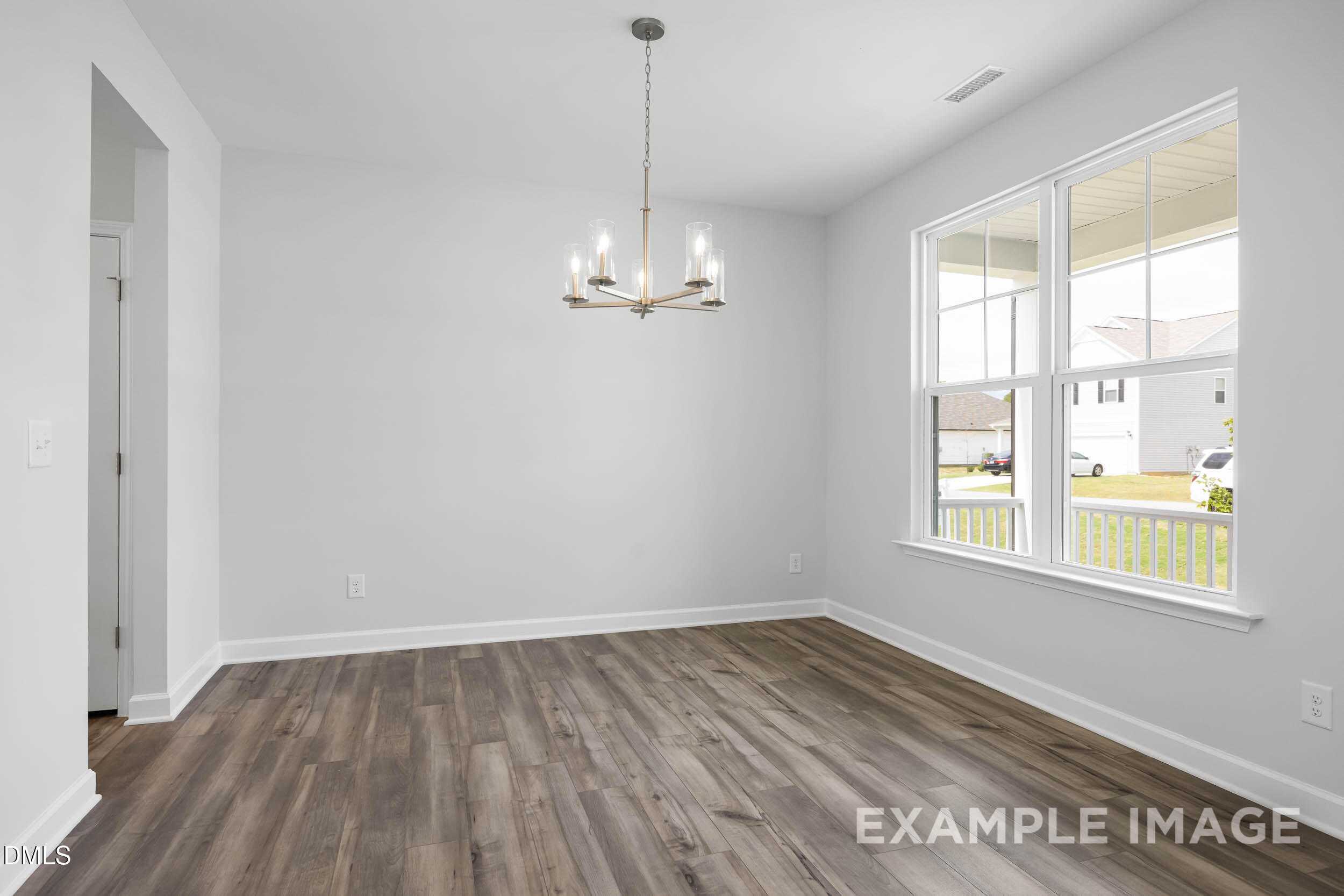 Elegant dining room with chandelier, large windows to porch, hardwood floors in Davidson Homes The Ash B, Lillington, NC