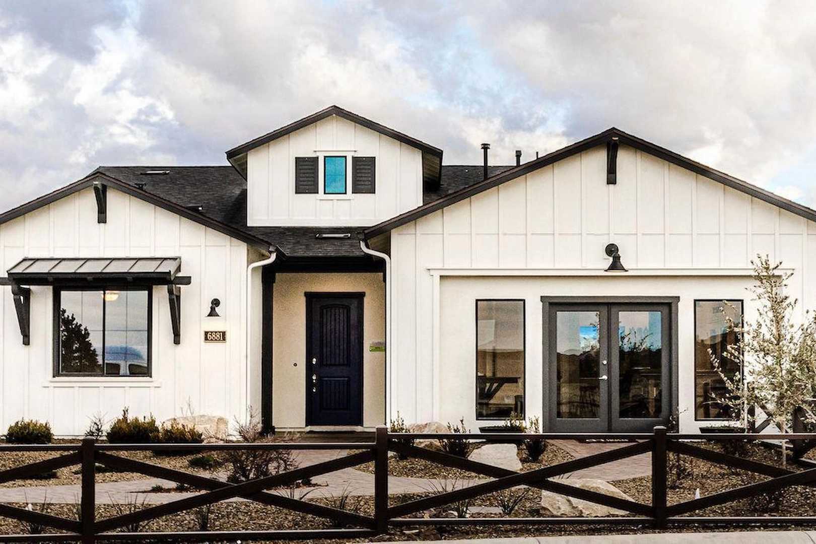 Modern farmhouse home exterior in Westwood Prescott AZ by Davidson Homes with white siding, covered porch, large windows, and desert fence