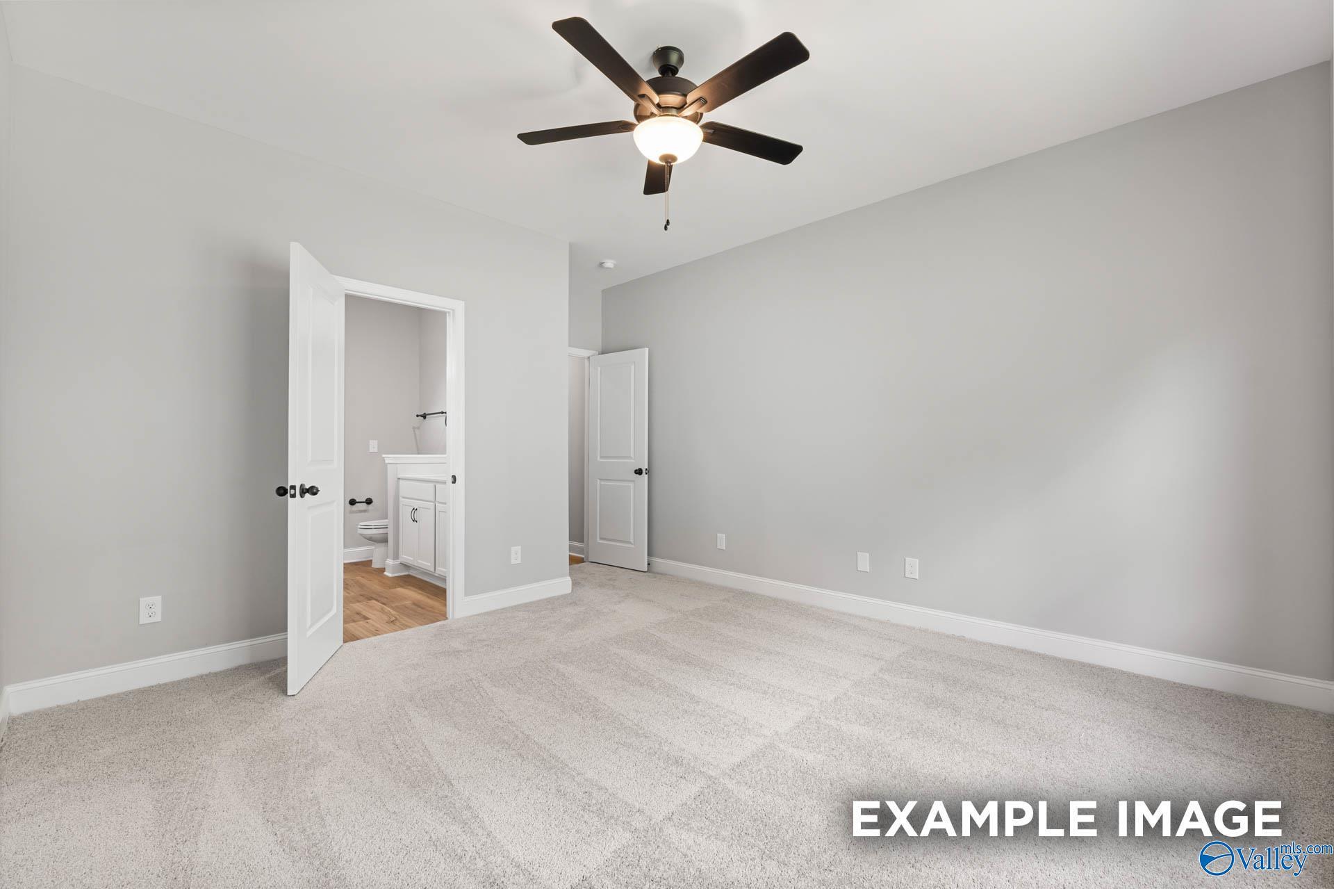Spacious master bedroom with ceiling fan, gray walls, and open en-suite bath in The Asheville C by Davidson Homes, Hazel Green, AL