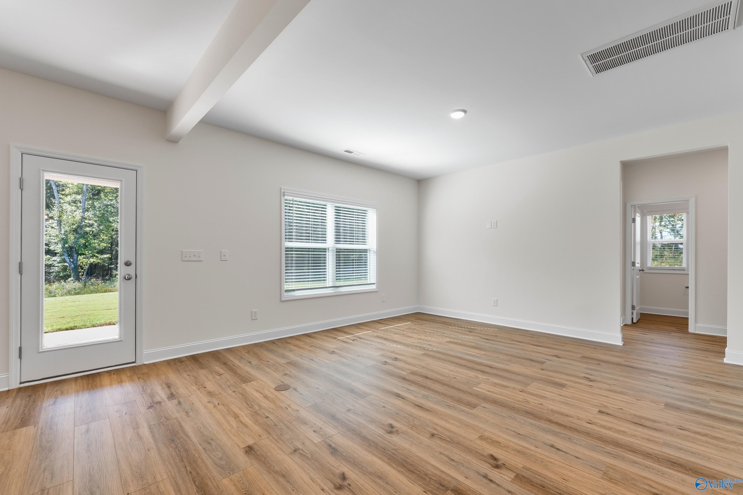 Bright family room with hardwood floors, French doors to lush backyard, and natural light in Davidson Homes The Shelby A, Athens Alabama