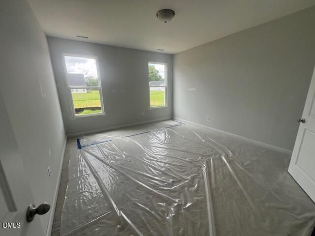 Bright, unfinished secondary bedroom in The Ash B floor plan at Retreat at North Main in Lillington, North Carolina.