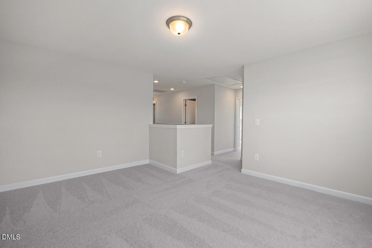 Spacious carpeted upper-level loft in The Grace C floor plan by Davidson Homes at Retreat at North Main, Lillington, NC.