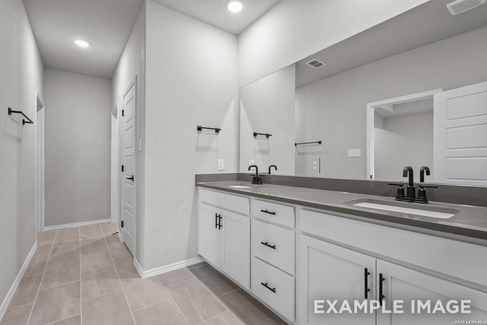 Modern bathroom with dual vanities, white cabinets, and matte black fixtures in The Glenwood E, Royal Crest, San Antonio.