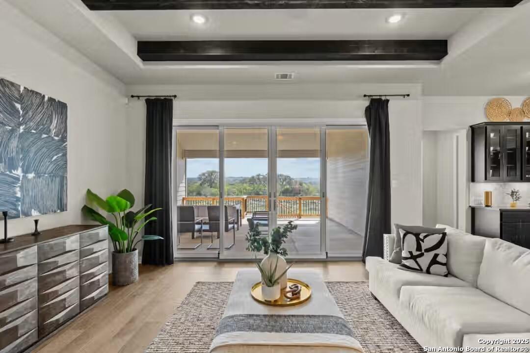 Bright living room with sliding doors to covered patio and wooded view in Davidson Homes The Summerlin B, Castroville, Texas