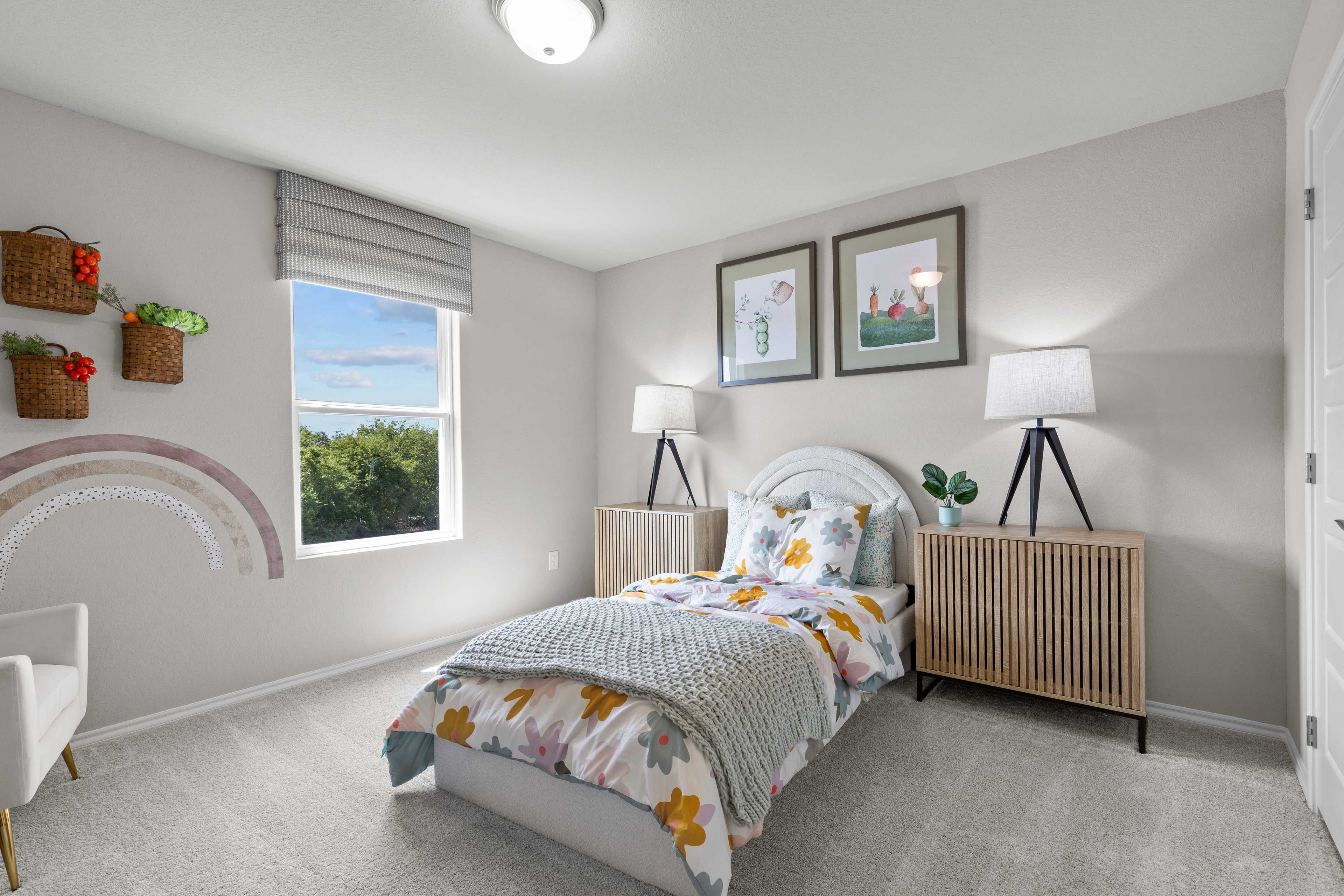 Charming girl's bedroom at Comanche Ridge in San Antonio TX by Davidson Homes featuring floral bed, nightstands, and window view