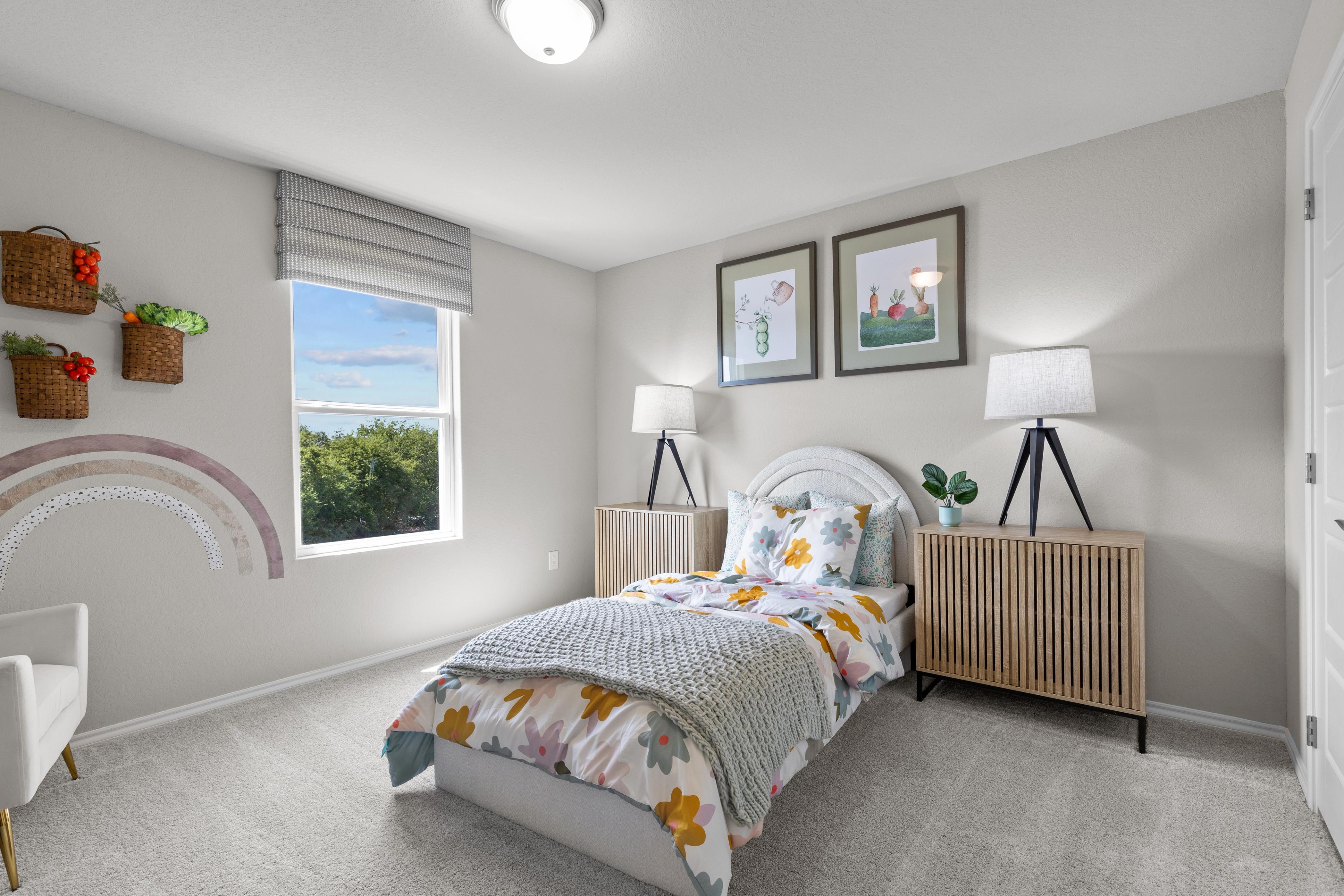 Charming girl's bedroom at Comanche Ridge in San Antonio TX by Davidson Homes featuring floral bed, nightstands, and window view
