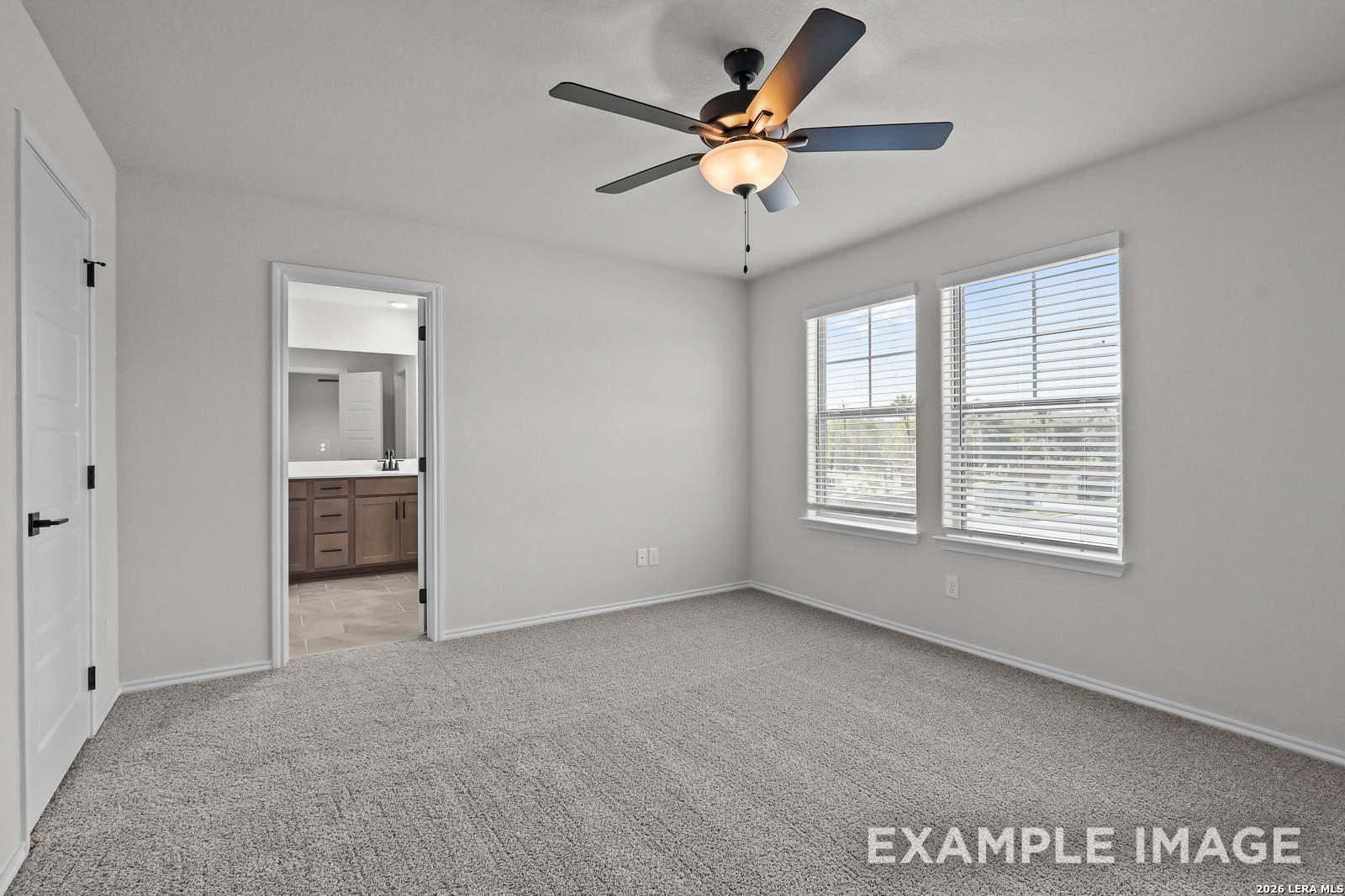 Spacious bedroom with carpet, ceiling fan, and en-suite bathroom in The Florence D floor plan by Davidson Homes, San Antonio.