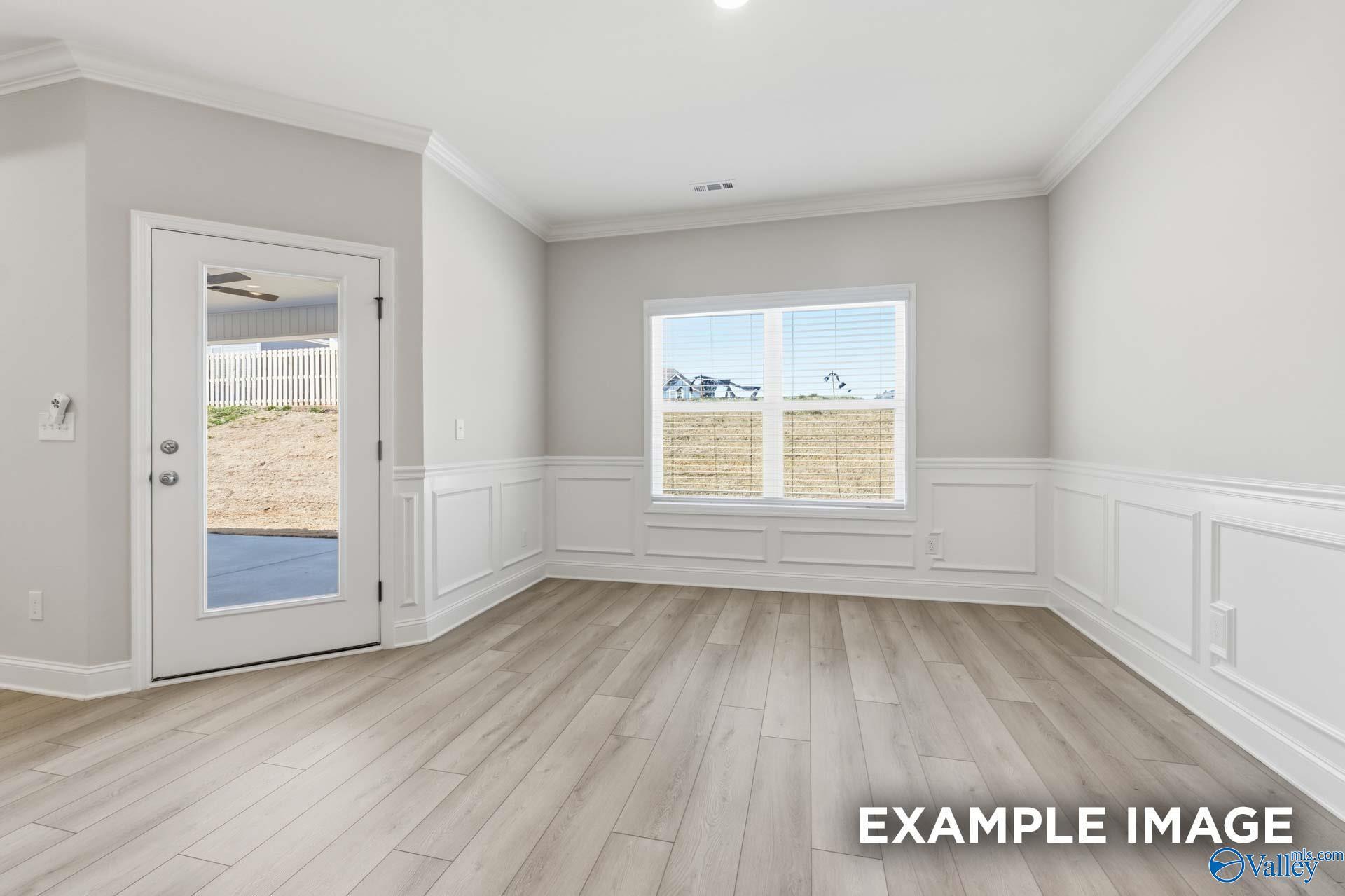 Bright study with wainscoting, light hardwood floors, and French door to backyard in Davidson Homes The Harrison C, Madison, Alabama