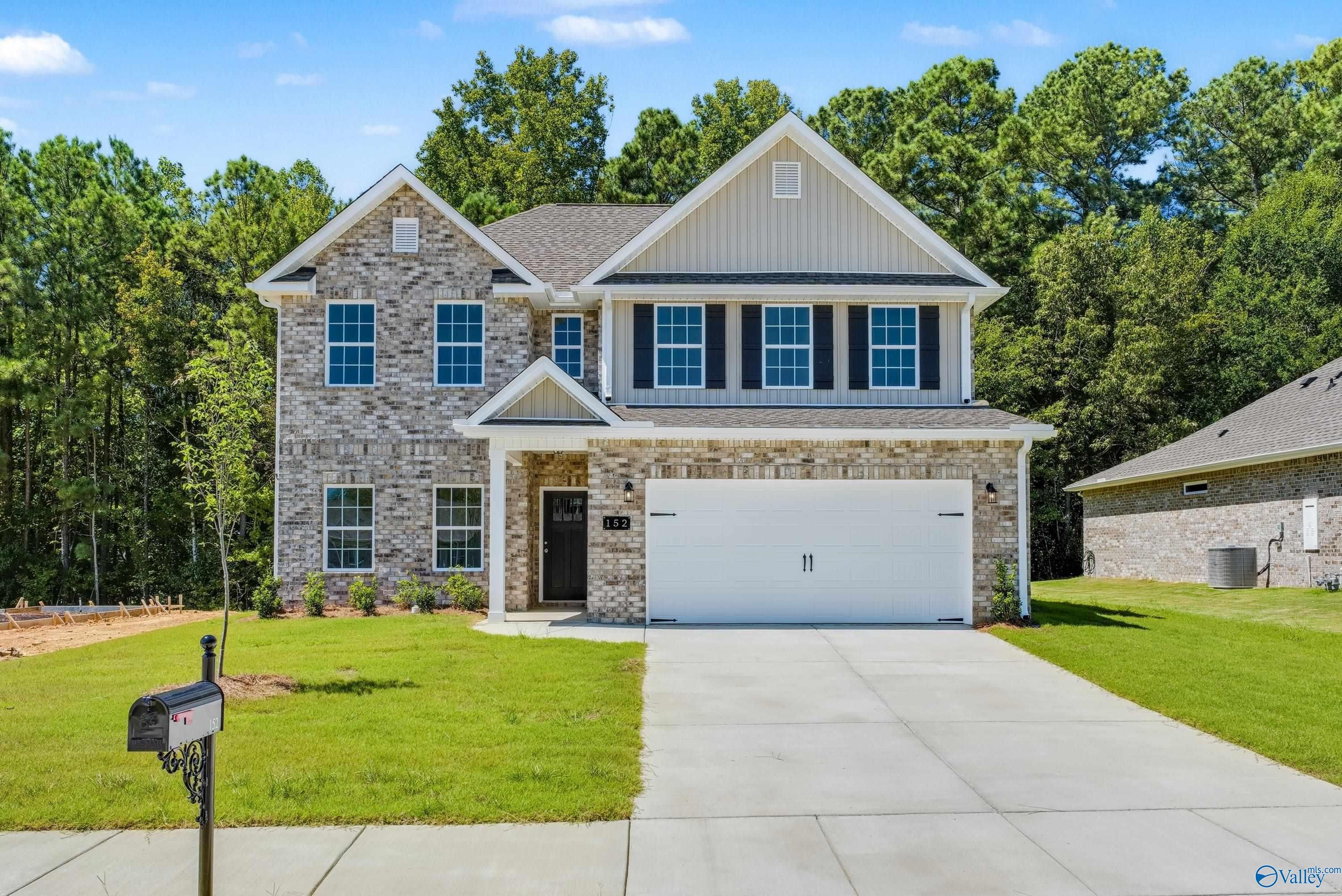 Two-story brick 4-bedroom home with 2-car garage, driveway, and lush lawn in The Highlands, Arab, Alabama by Davidson Homes
