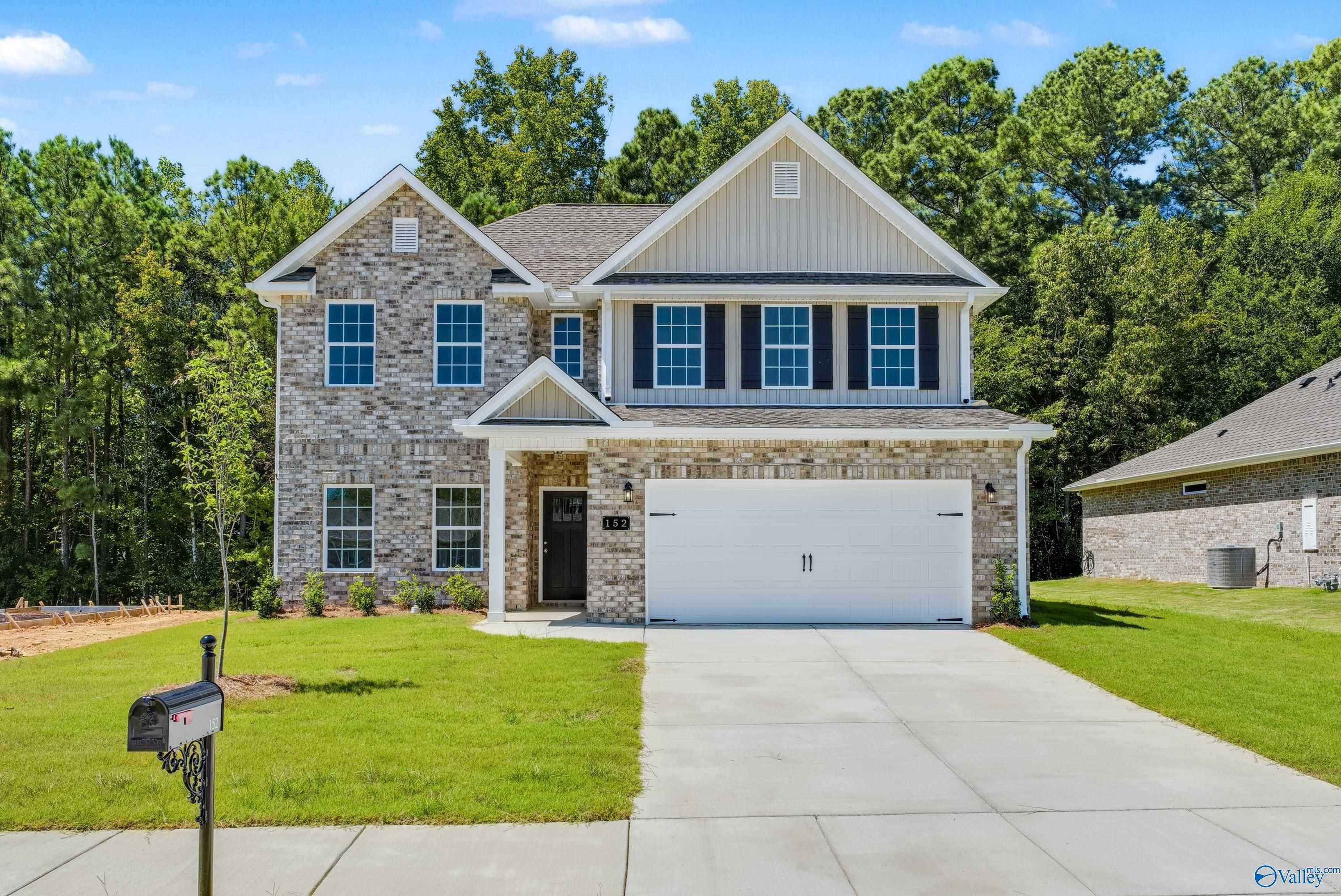 Two-story brick 4-bedroom home with 2-car garage, driveway, and lush lawn in The Highlands, Arab, Alabama by Davidson Homes