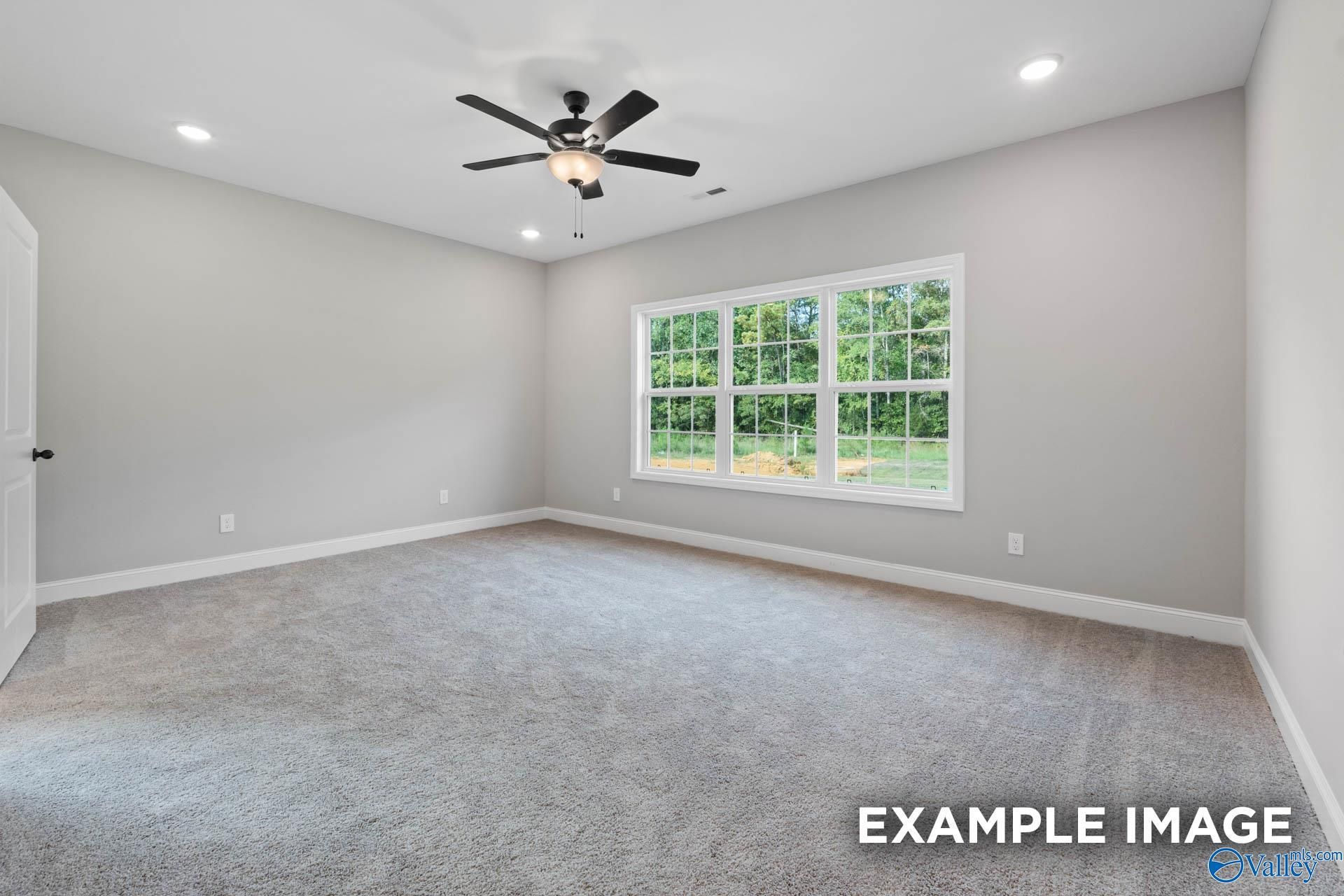 Bright secondary bedroom with gray walls, ceiling fan, plush carpet, and large windows in Davidson Homes Montgomery B, Toney, AL