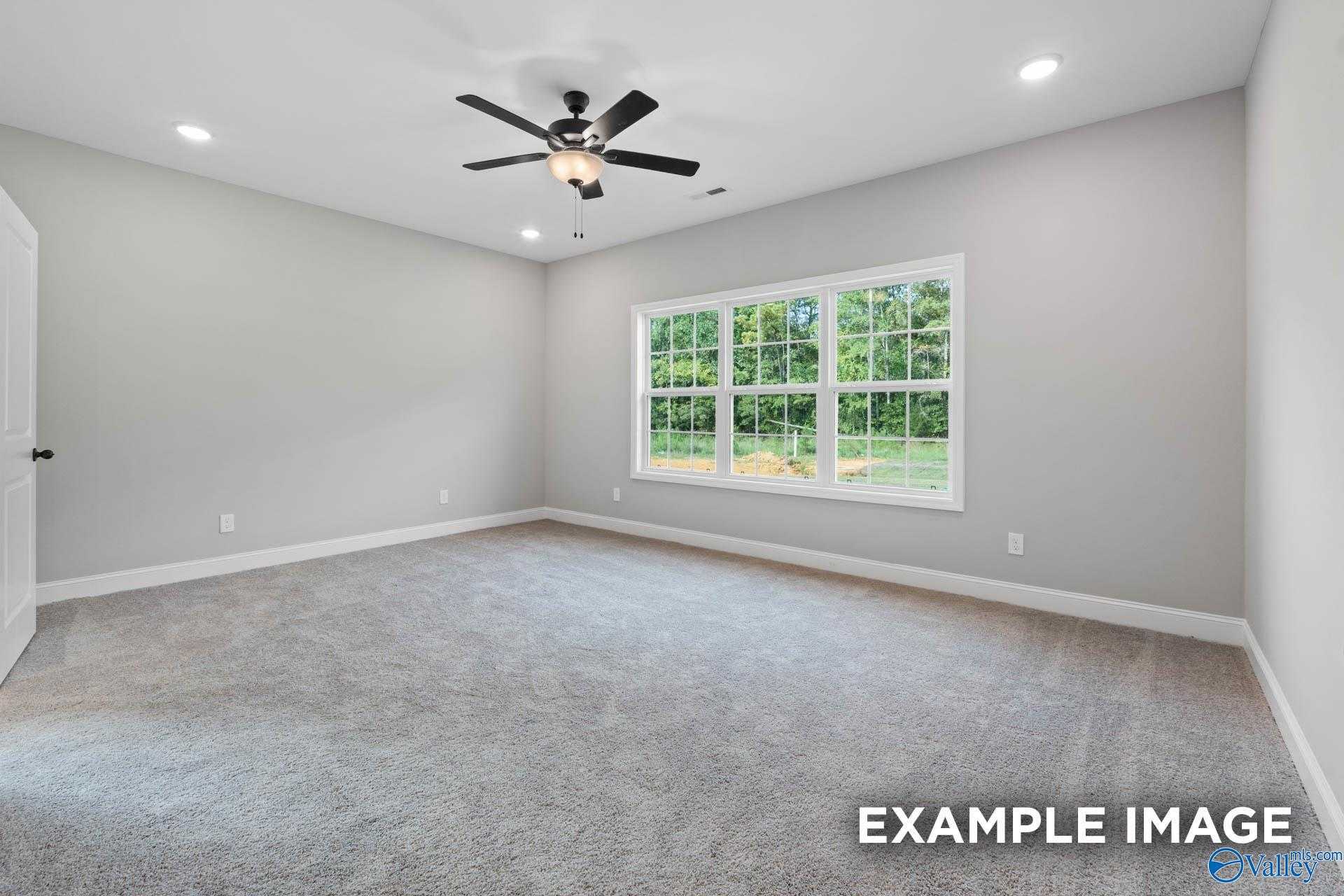 Bright secondary bedroom with gray walls, ceiling fan, plush carpet, and large windows in Davidson Homes Montgomery B, Toney, AL