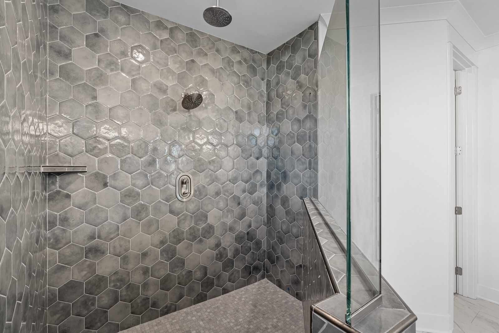 Modern gray hexagonal tile walk-in shower with rainfall head and glass enclosure in Davidson Homes The Hawkins bathroom, Murfreesboro, TN