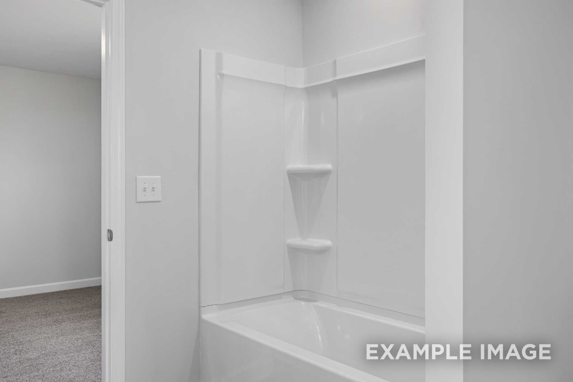 Modern master bathroom in The Gavin C with white bathtub, walk-in shower, and built-in shelves by Davidson Homes