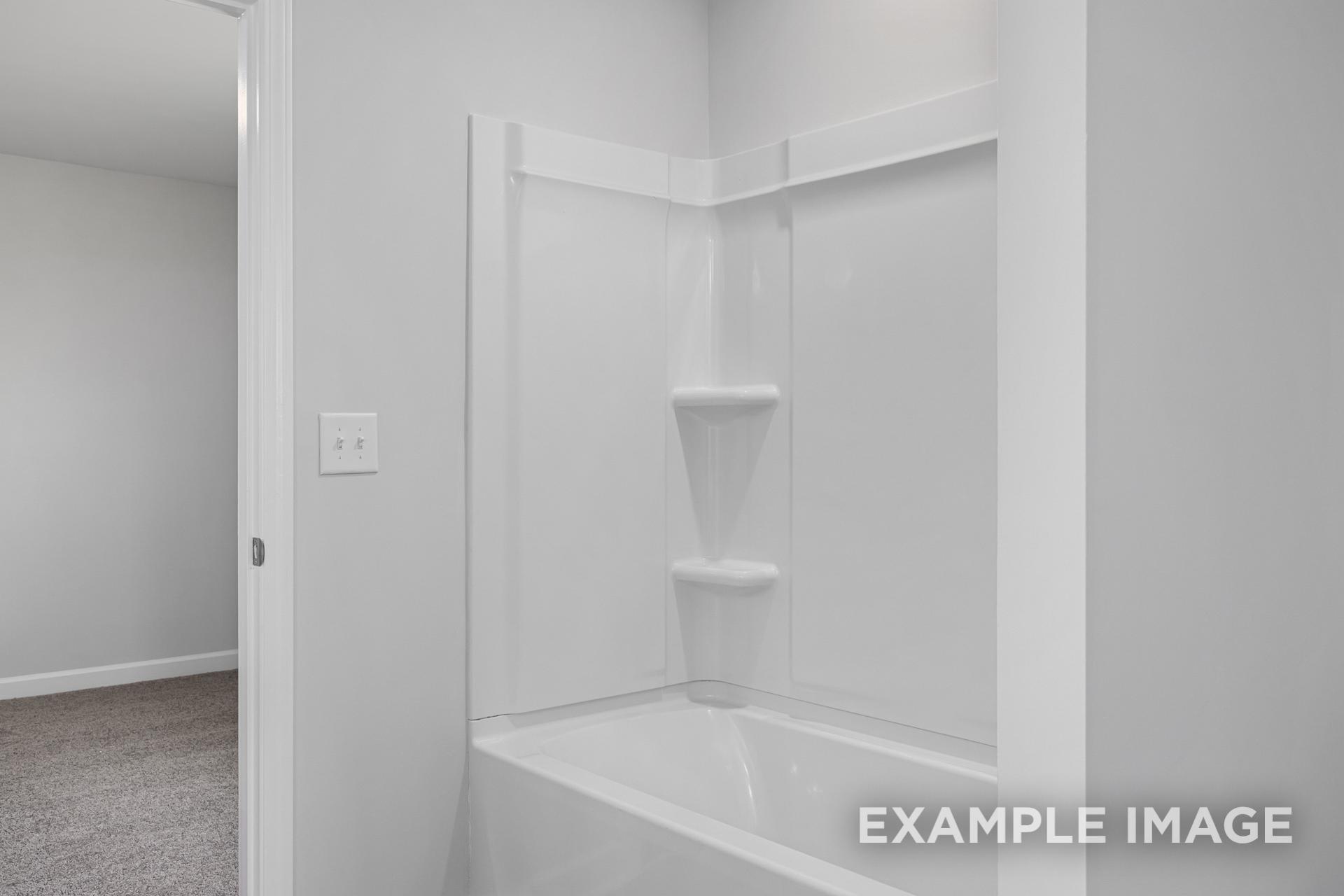 Modern bathroom in The Gavin B home with white bathtub, walk-in shower, and built-in shelves