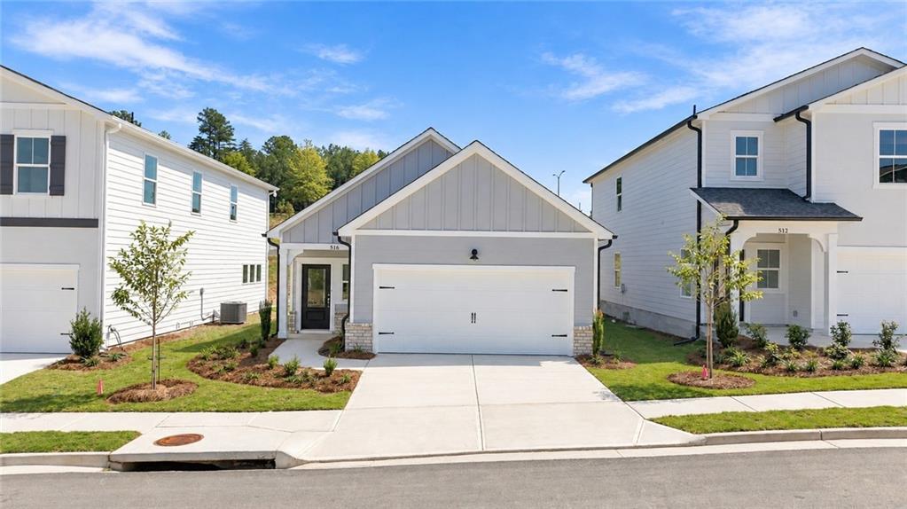 Front exterior of The Oconee B single-story home by Davidson Homes with 2-car garage in The Bluffs, Canton, Georgia