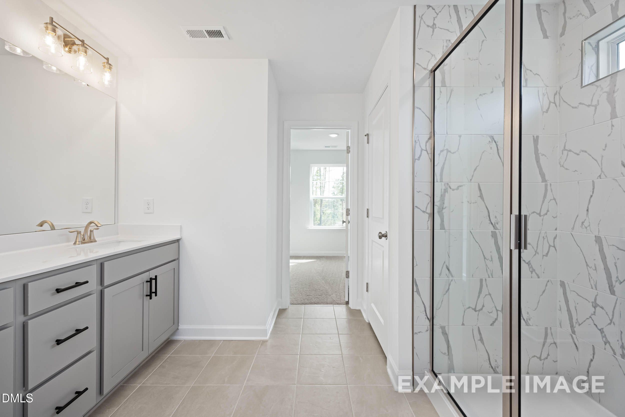 Modern master bathroom with double gray vanity, frameless glass shower, and white subway tiles in Davidson Homes The Willow D, Zebulon, NC