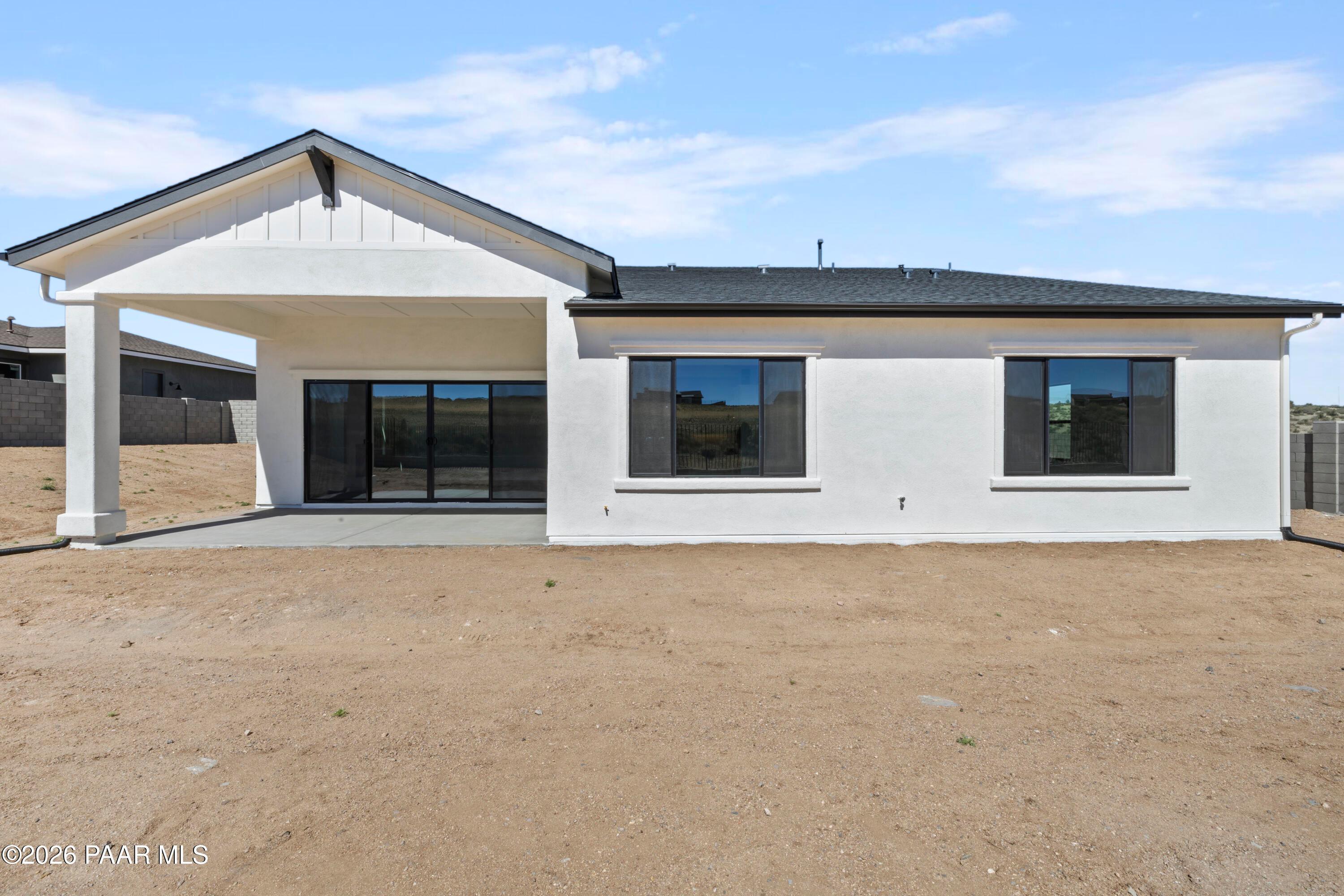 Modern rear view of The Soleil E single-story home with covered patio, sliding glass doors, and large windows in Hidden Hills, Prescott, Arizona