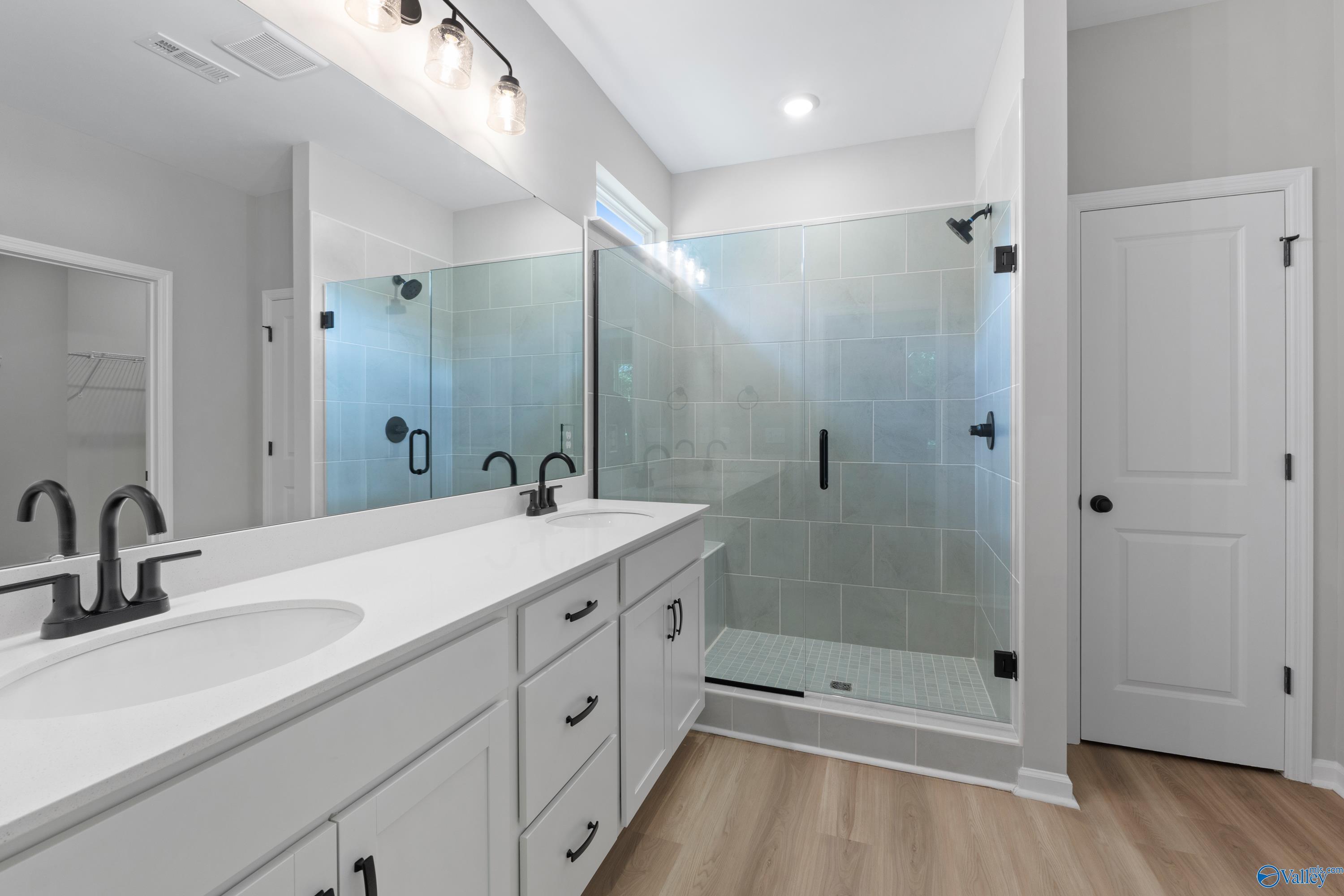 Modern master bathroom featuring double vanity, frameless glass shower with subway tile in Davidson Homes The Phoenix, Hazel Green, Alabama