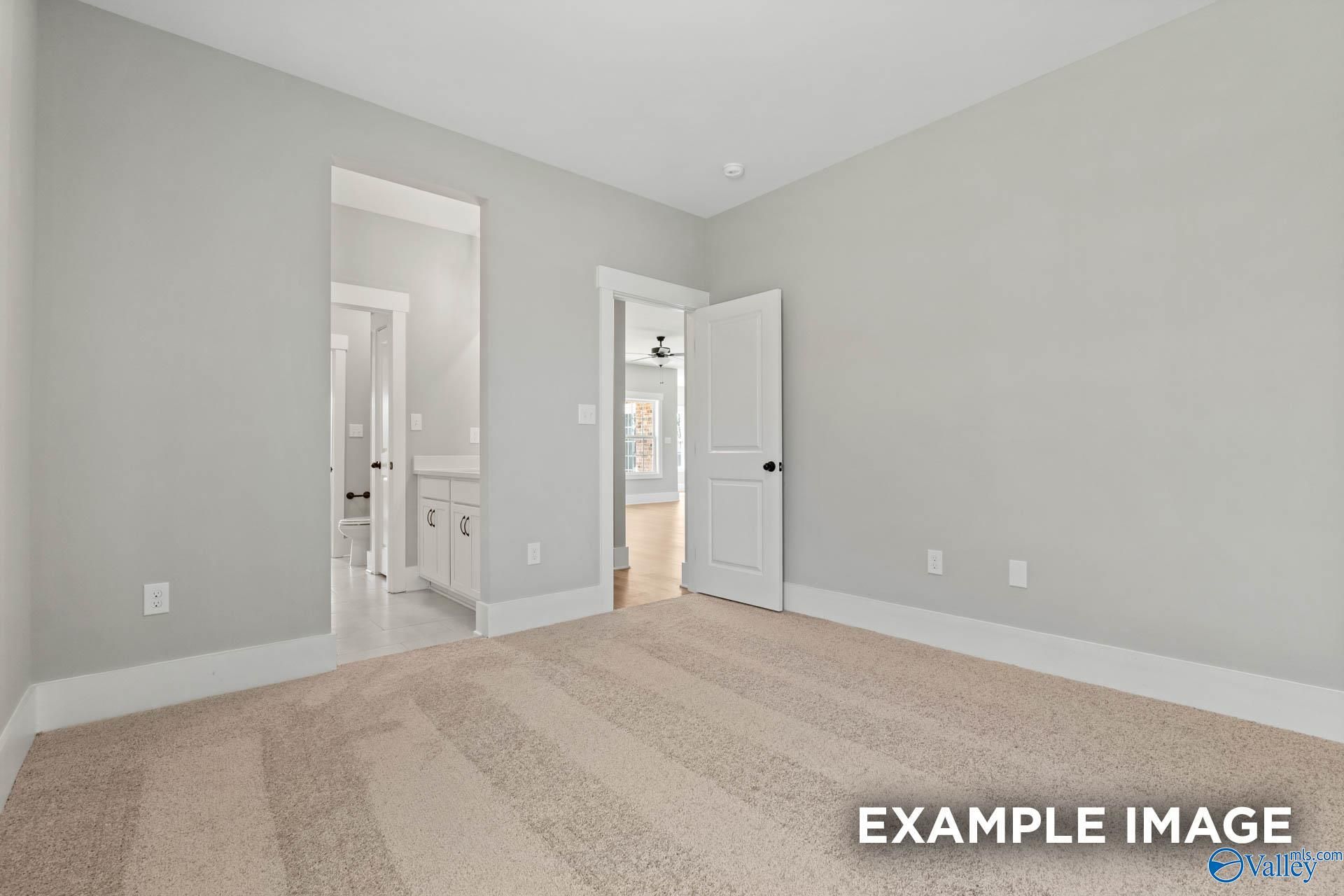 Spacious bedroom with plush carpet and ensuite bathroom in The Finleigh floor plan at Briercreek, Meridianville, Alabama.