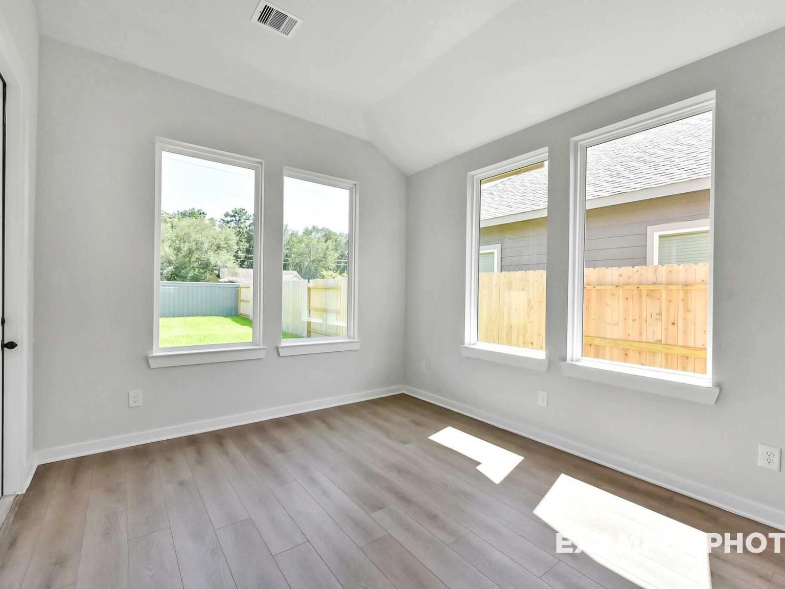 Bright breakfast nook with large windows and wood-look flooring in The Sequoia C floor plan at Sundance Cove, Crosby, TX.