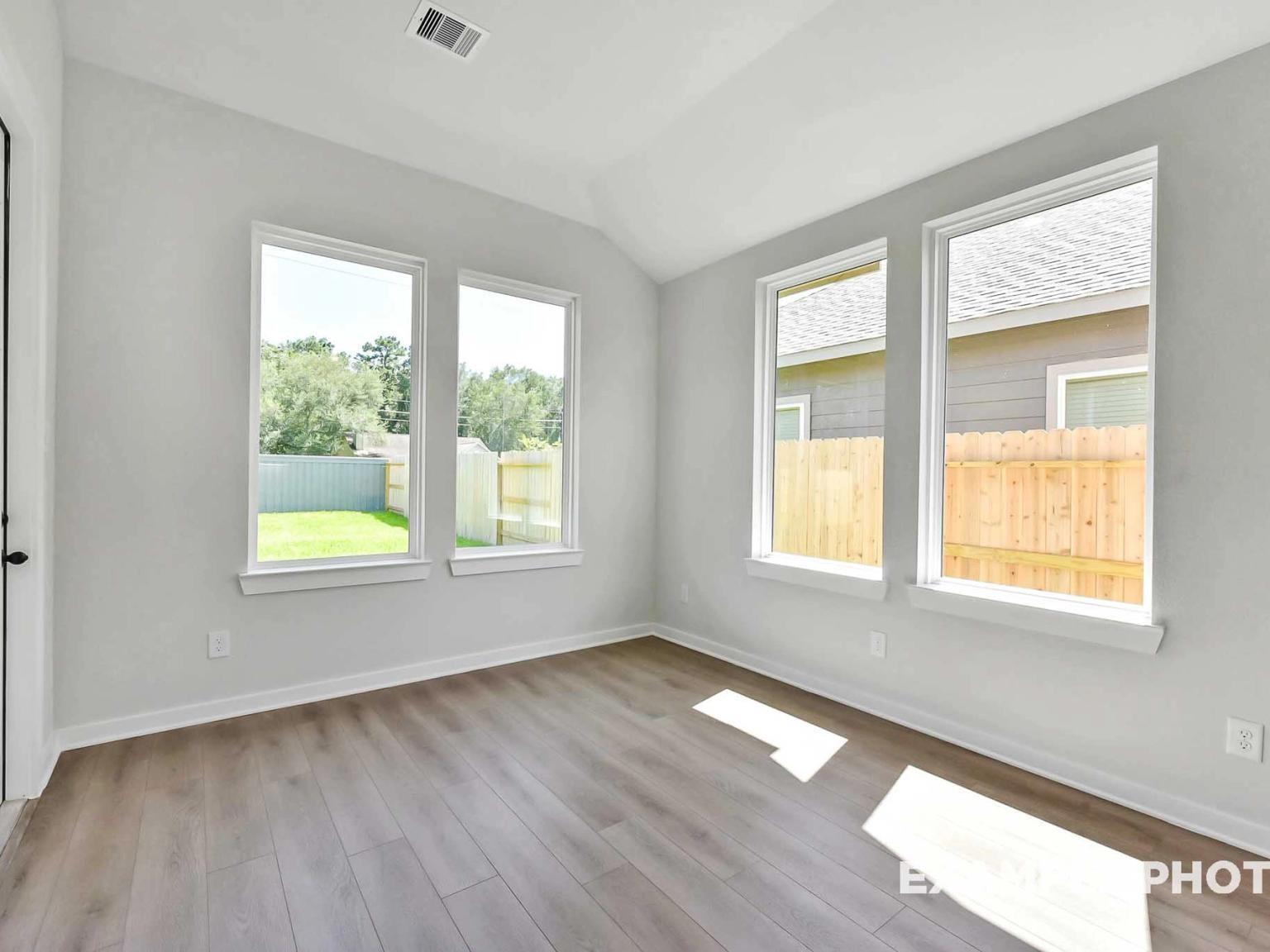 Bright breakfast nook with large windows and wood-look flooring in The Sequoia C floor plan at Sundance Cove, Crosby, TX.