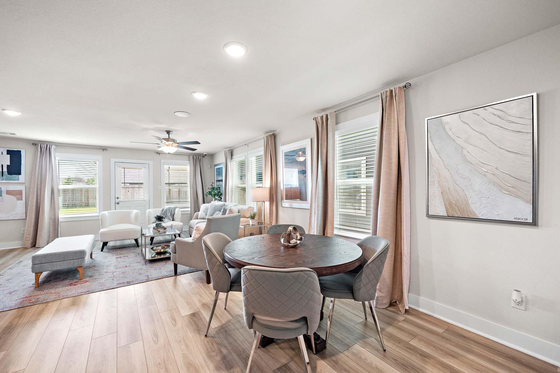 Open-concept living dining area at Haven at Kieth Harrow in Cypress TX with hardwood floors, round table, and modern seating