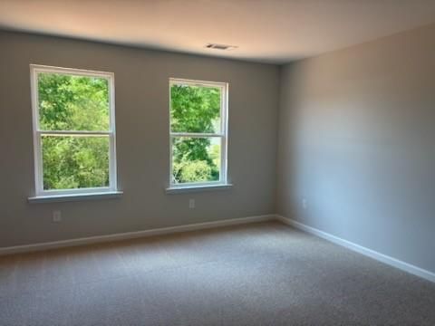 Bright empty bedroom with large windows and natural light in Davidson Homes The Rabun A, Winder, Georgia