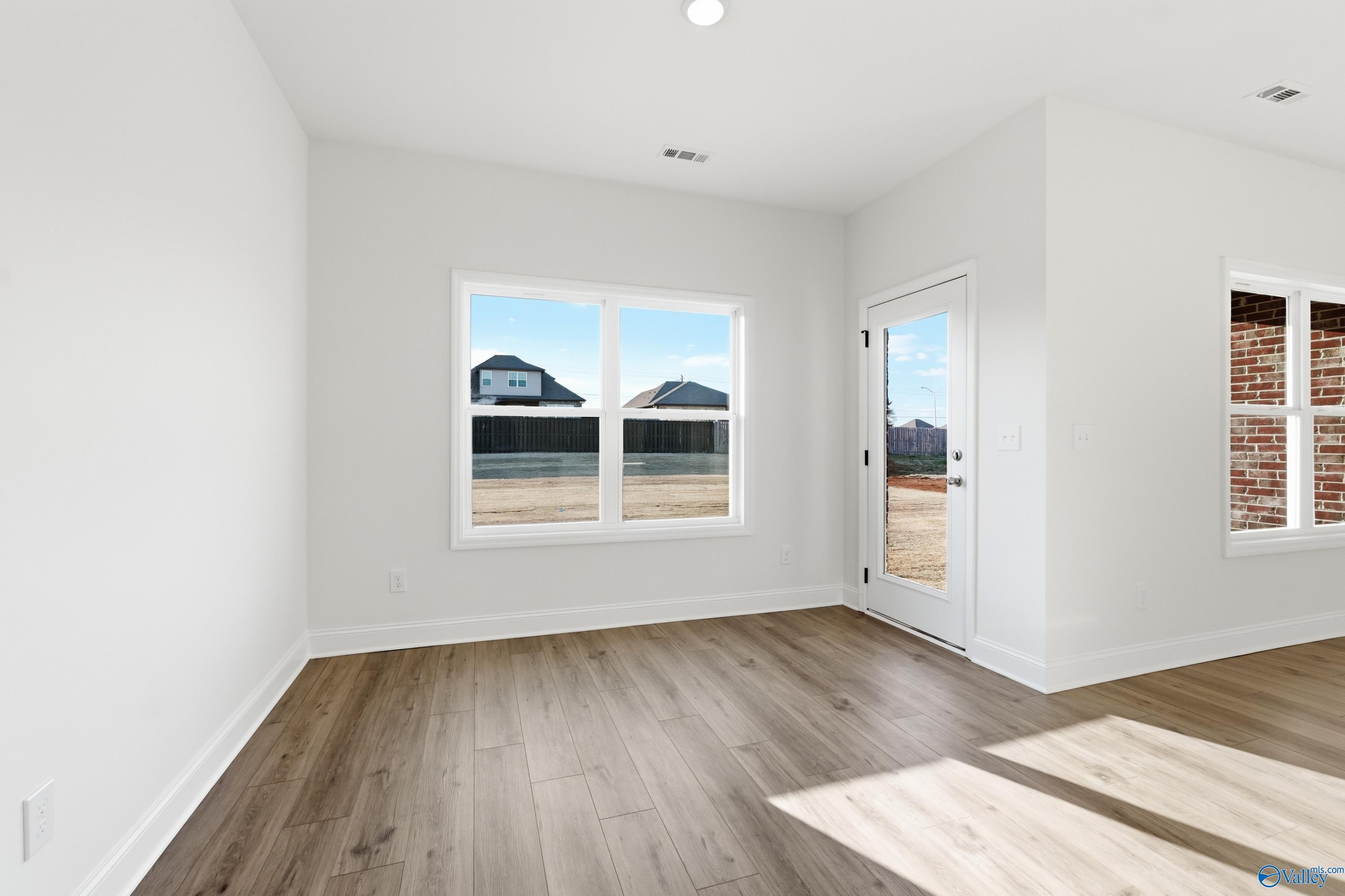 Bright flex room with hardwood floors, large windows overlooking neighborhood homes in Davidson Homes The Asheville C, Meridianville, Alabama