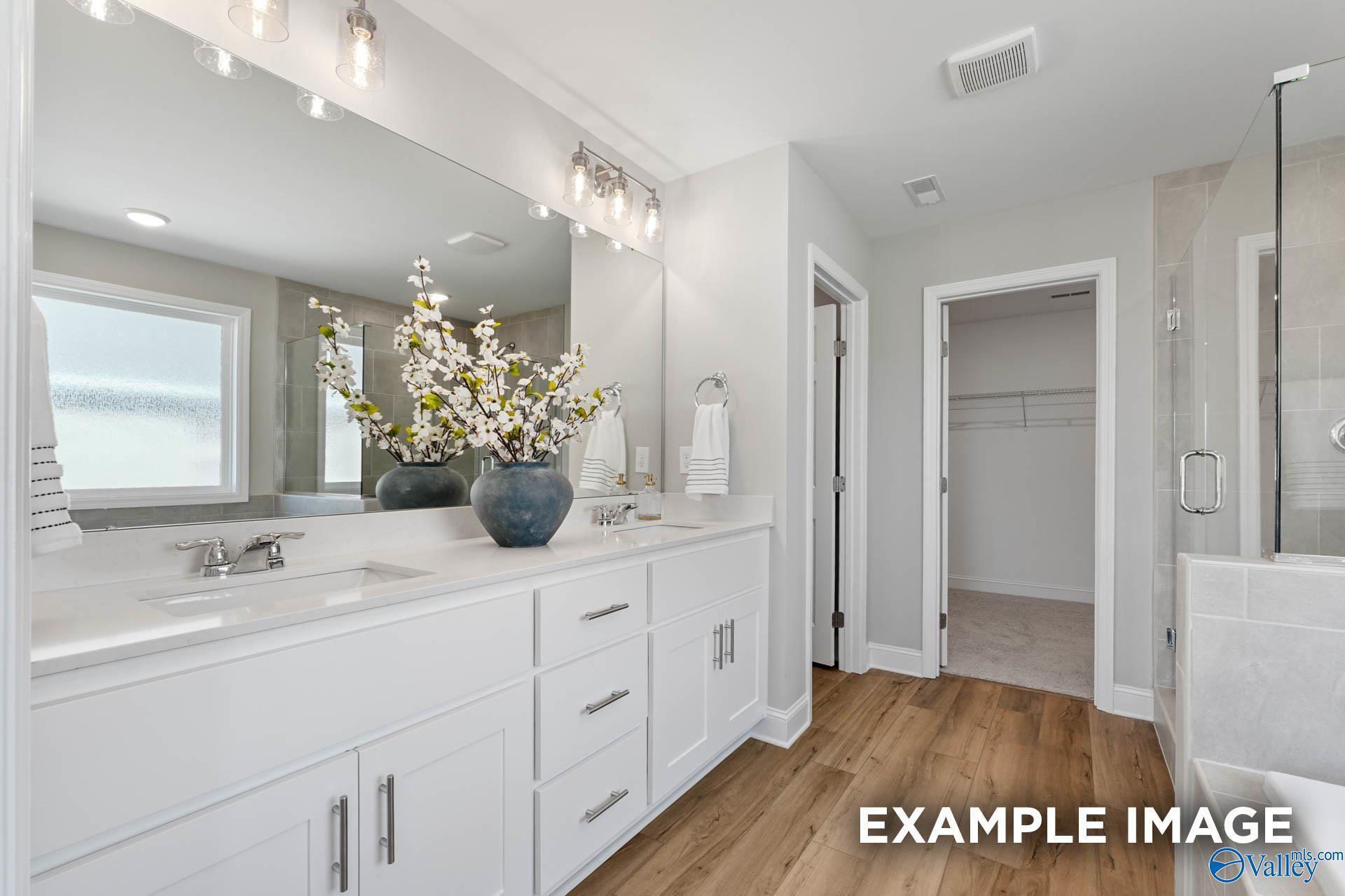 Elegant master bathroom double vanity with quartz counters, large mirror, and cherry blossoms in Davidson Homes Chelsea B, Toney AL