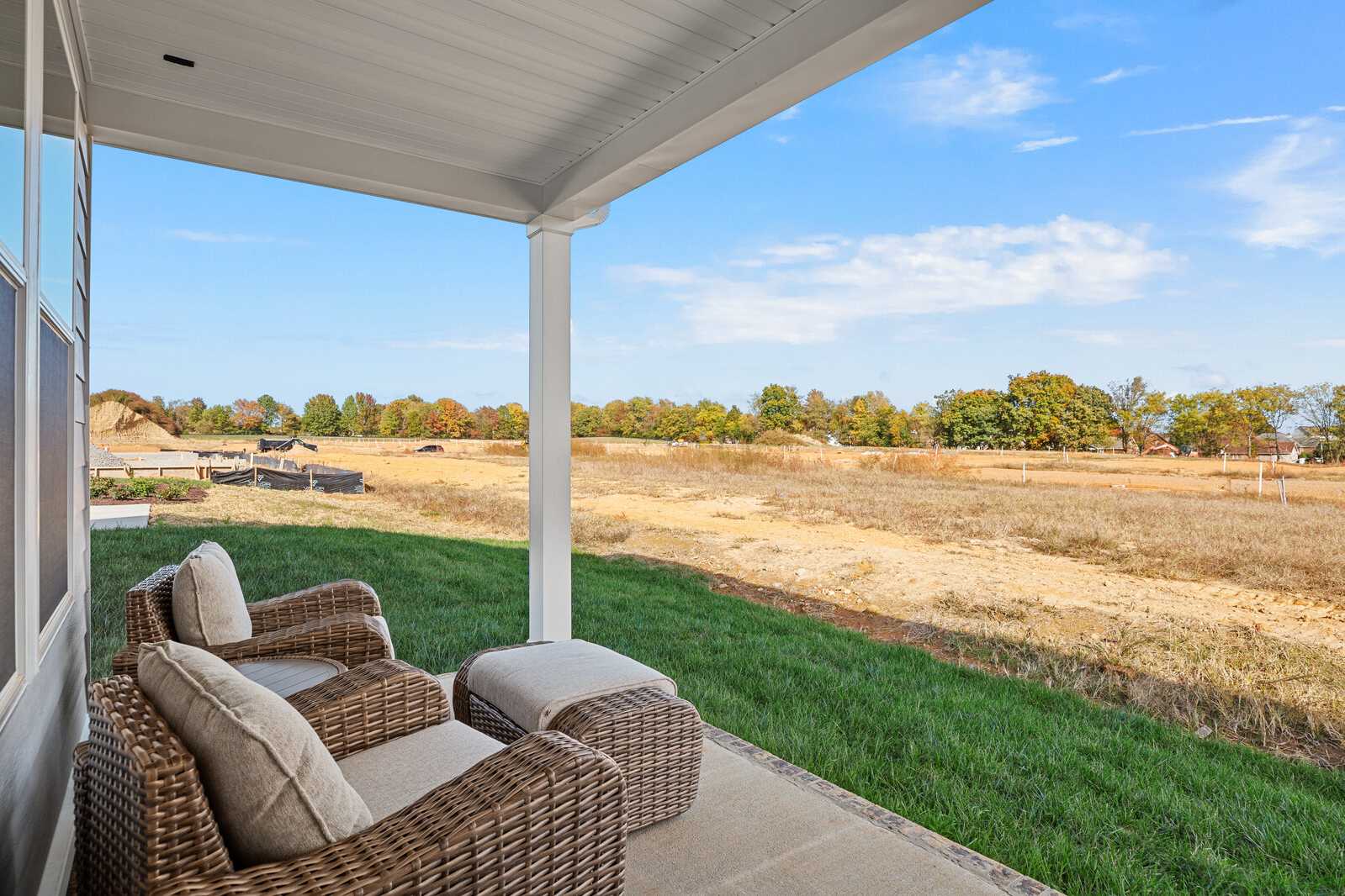 Covered porch at Sage Farms in White House Tennessee with wicker chairs overlooking golden autumn fields