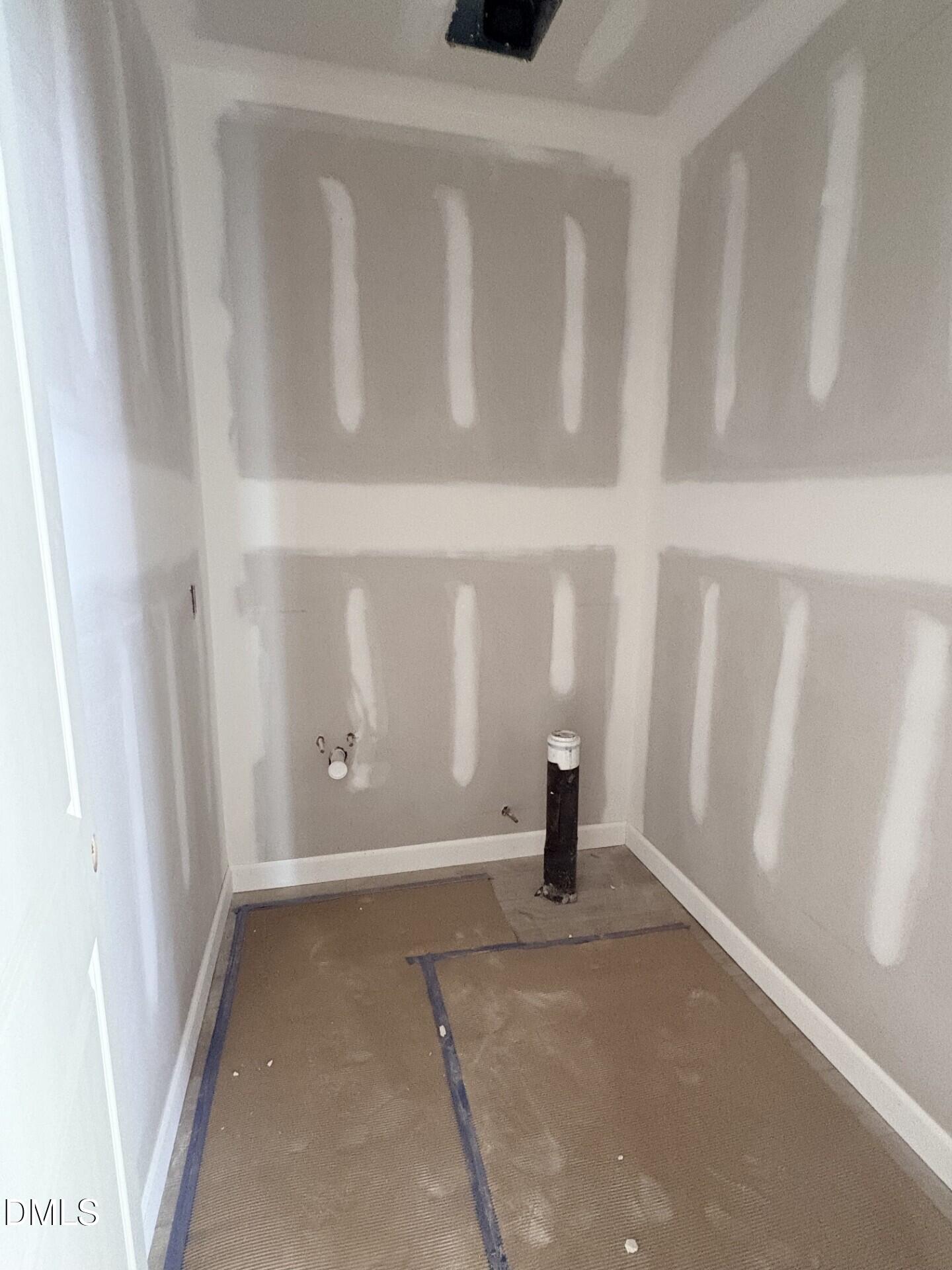 Unfinished laundry room with plumbing hookups in The Ash C floor plan at Woodland Crossing in Zebulon, North Carolina.