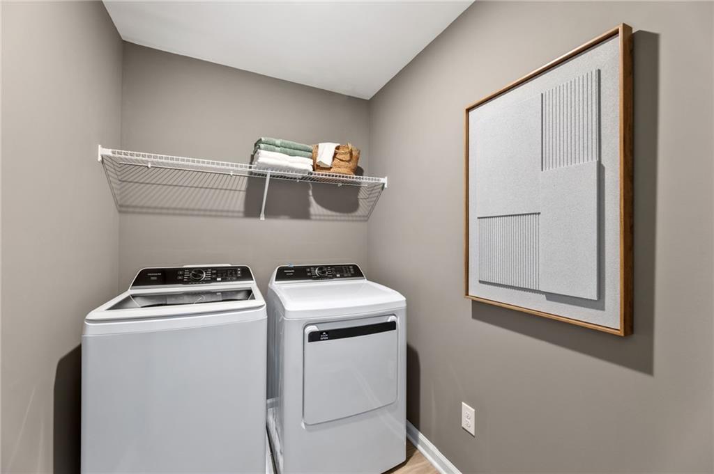 Laundry room with washer, dryer, and storage shelving in The Rabun B floor plan at The Bluffs in Canton, Georgia.