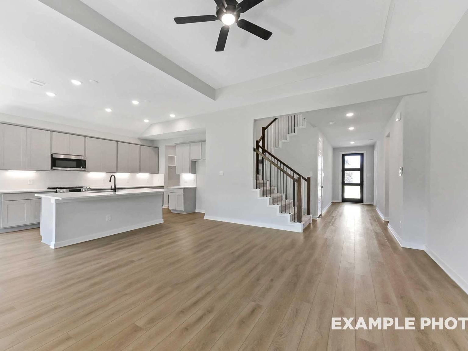 Open-concept kitchen and living area with hardwood floors in The Sequoia C floor plan by Davidson Homes in Crosby, Texas.
