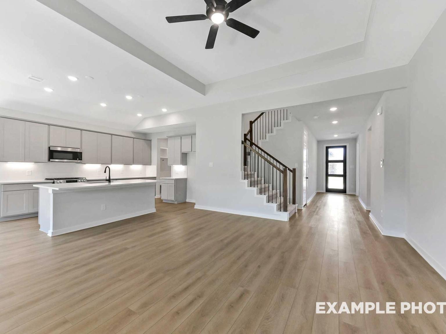 Open-concept kitchen and living area with hardwood floors in The Sequoia C floor plan by Davidson Homes in Crosby, Texas.