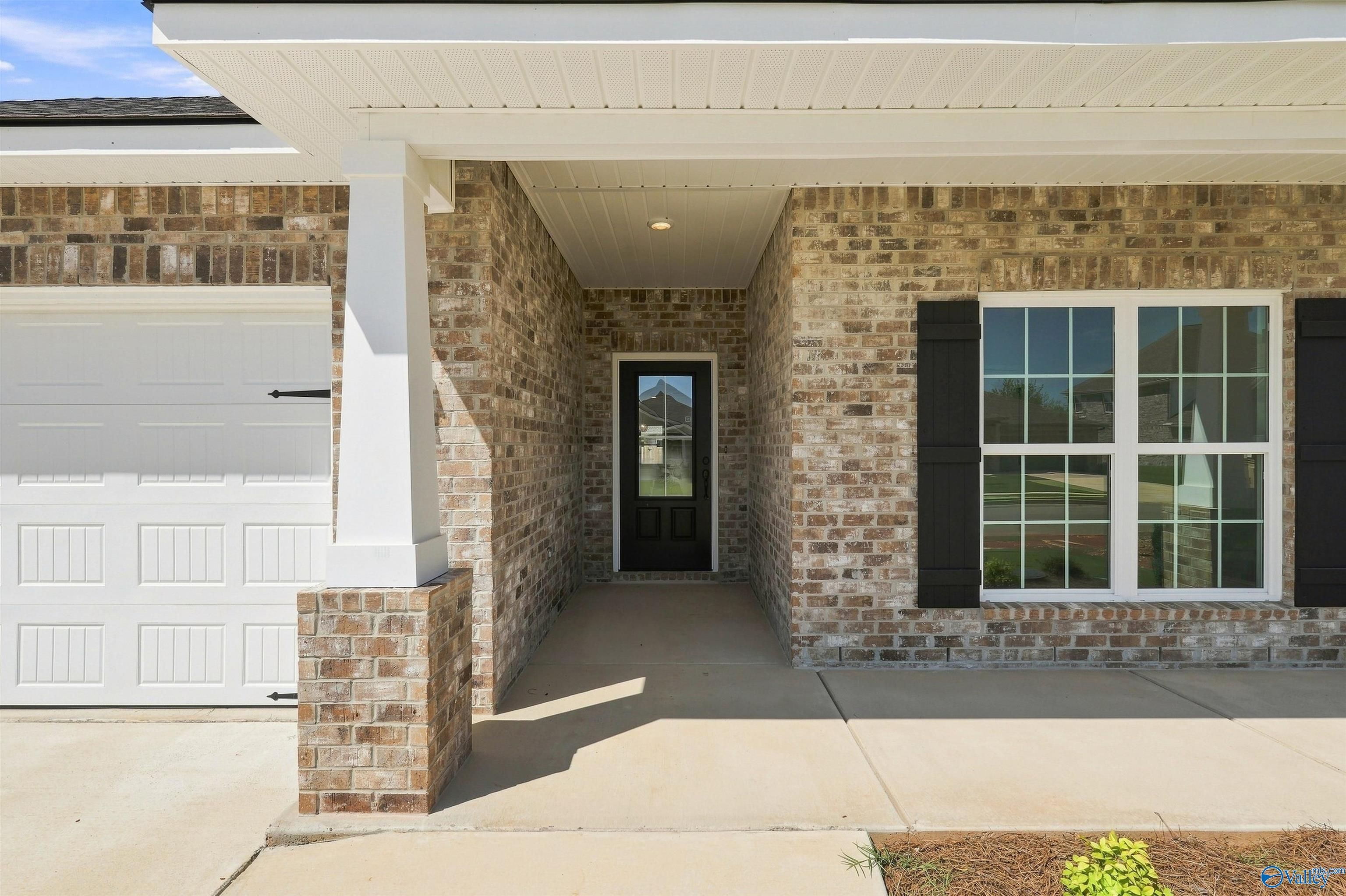 Covered brick front porch and entryway of The Everett B floor plan by Davidson Homes in Ivy Hills, Toney, Alabama.