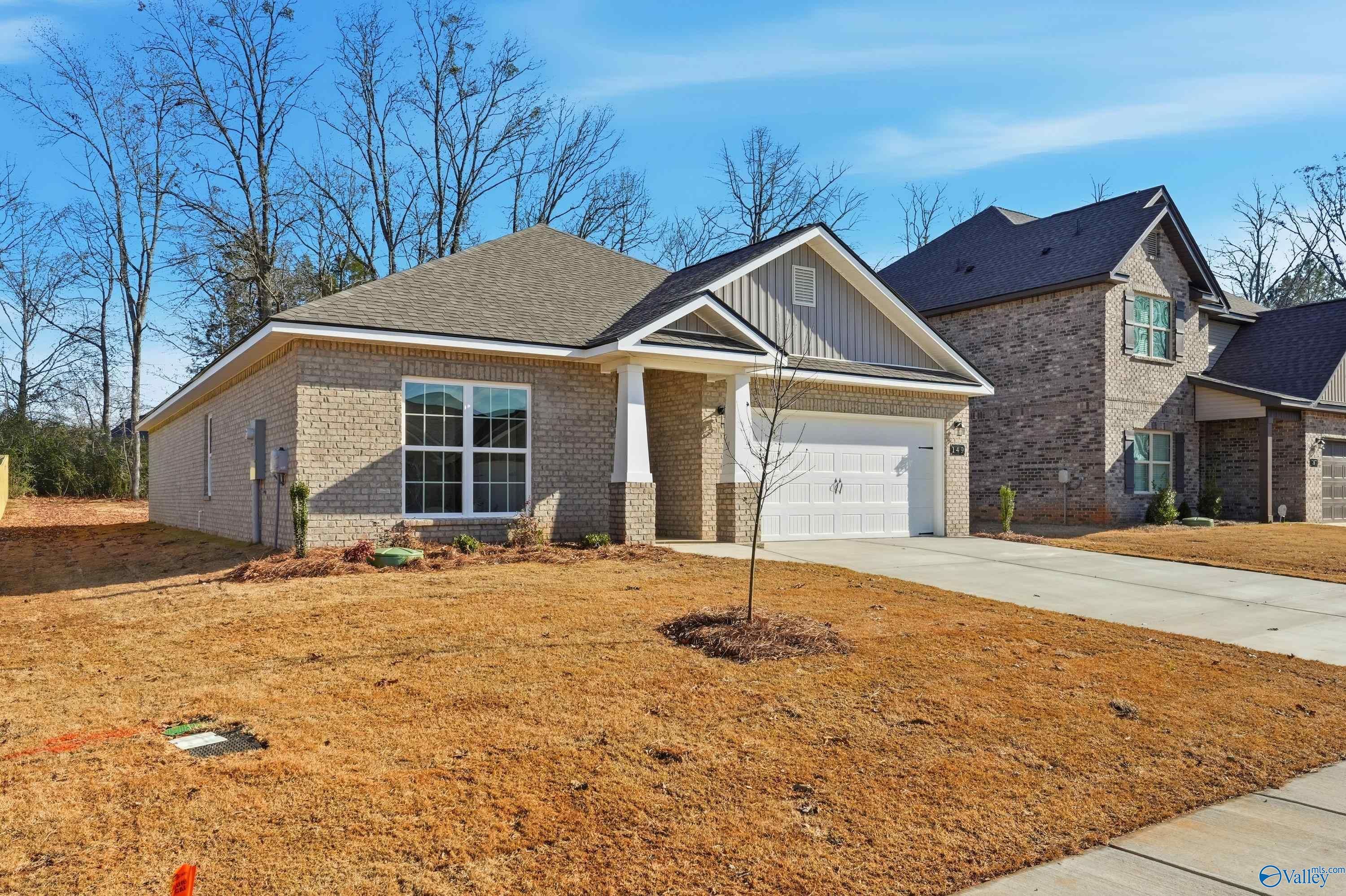 Single-story brick home with 2-car garage, gabled roof, and front yard in Creek Grove, New Market, Alabama by Davidson Homes