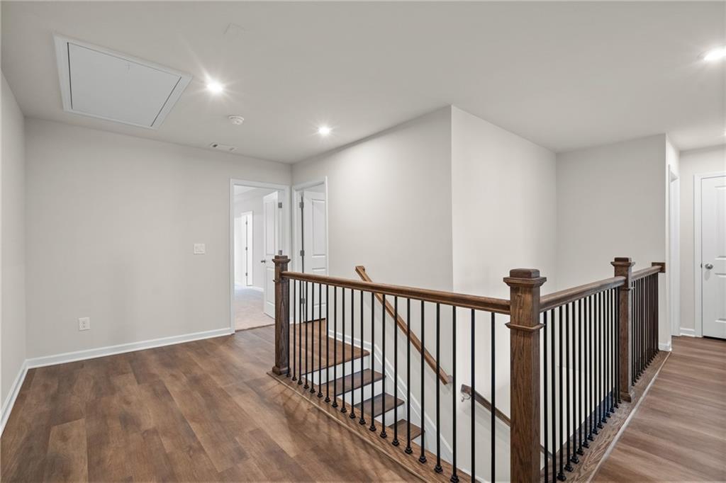 Upper hallway with wrought iron staircase and hardwood floors in Davidson Homes The Marion B, Kennesaw, Georgia