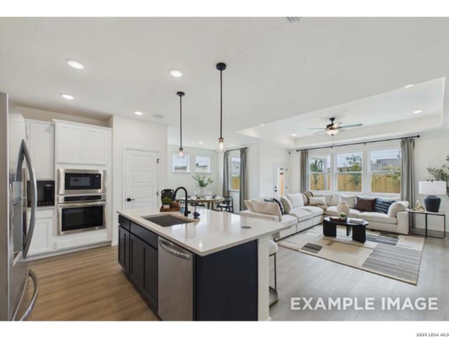 Open-concept kitchen and living area with large island in The Laurel G floor plan by Davidson Homes in San Antonio, Texas.