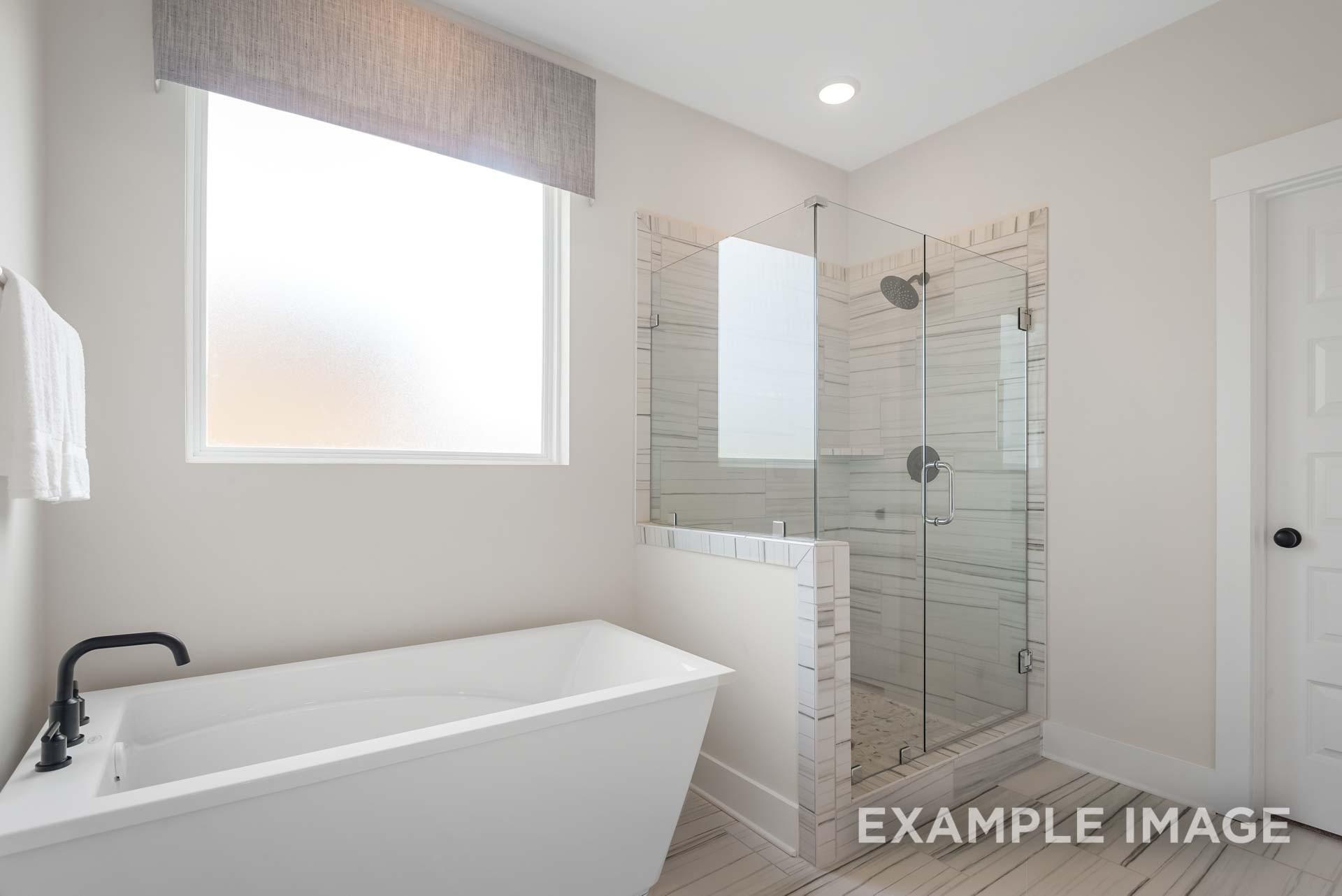 Elegant master bathroom featuring freestanding tub and frameless glass shower in Davidson Homes The Ridgeport, Gallatin, TN