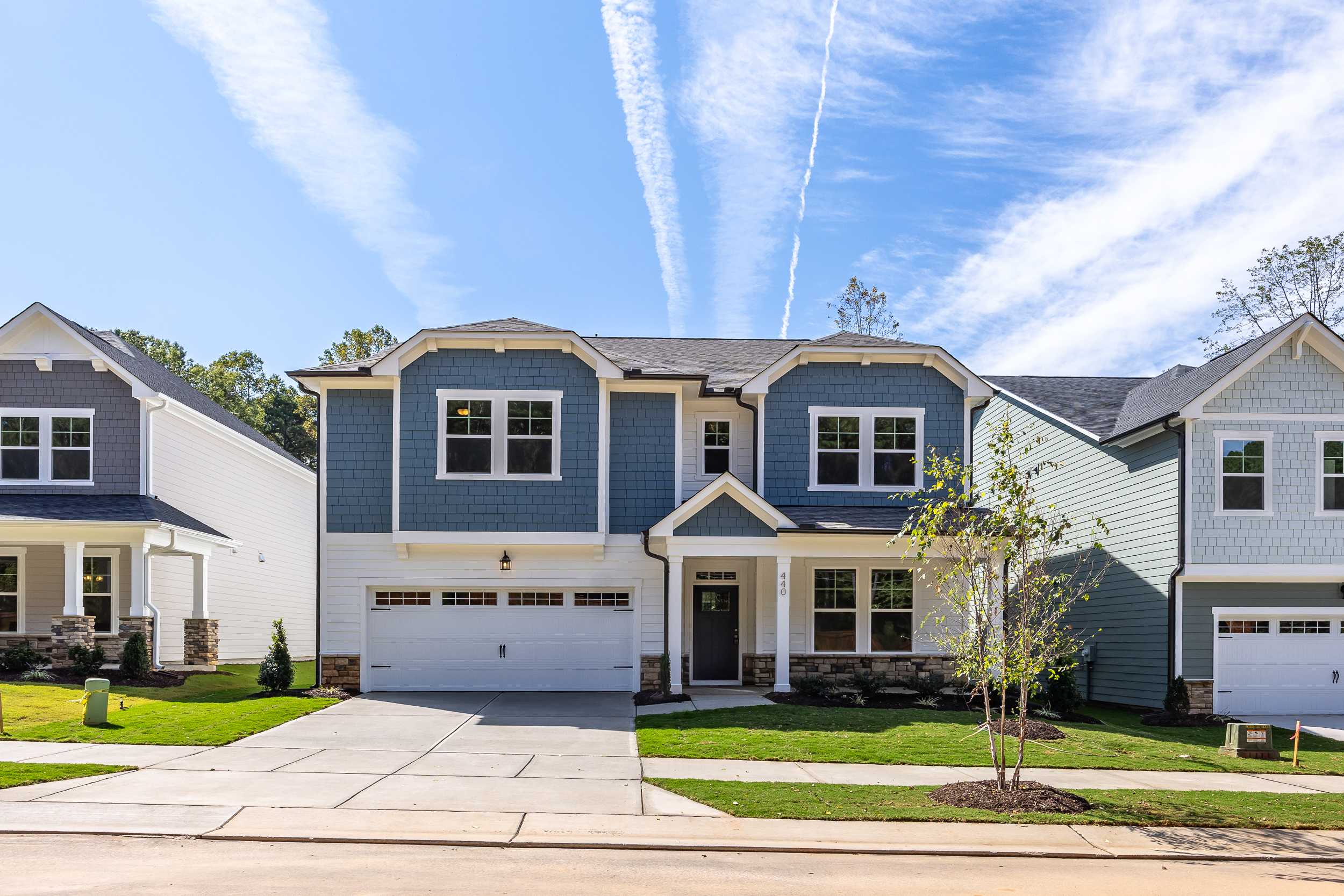 Two-story blue-gray sided The Beech C home exterior with two-car garage, driveway, and landscaping in Belmont NC